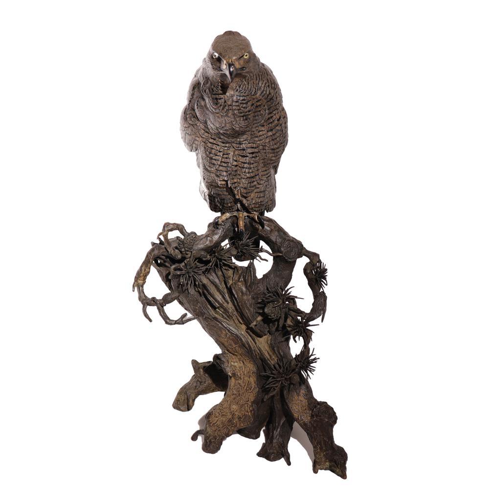 A bronze and mixed metal Okimono of a Kumataka Mountain Hawk-Eagle (Nisaetus nipalensis orientalis). Naturalistically cast as a raptor perched with one leg on an ancient pine tree, the feathers finely detailed with shibuichi (60% copper, 40%