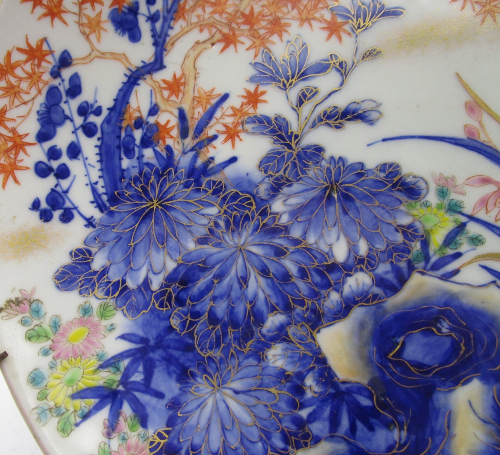 Exquisite late 19th century Japanese Fukagawa porcelain charger, circa 1890s, Meiji period (1868-1912).It depicts rocks and auspicious chrysanthemums in cobalt blue and maples in orange red, with generous gold details. The reverse side is decorated