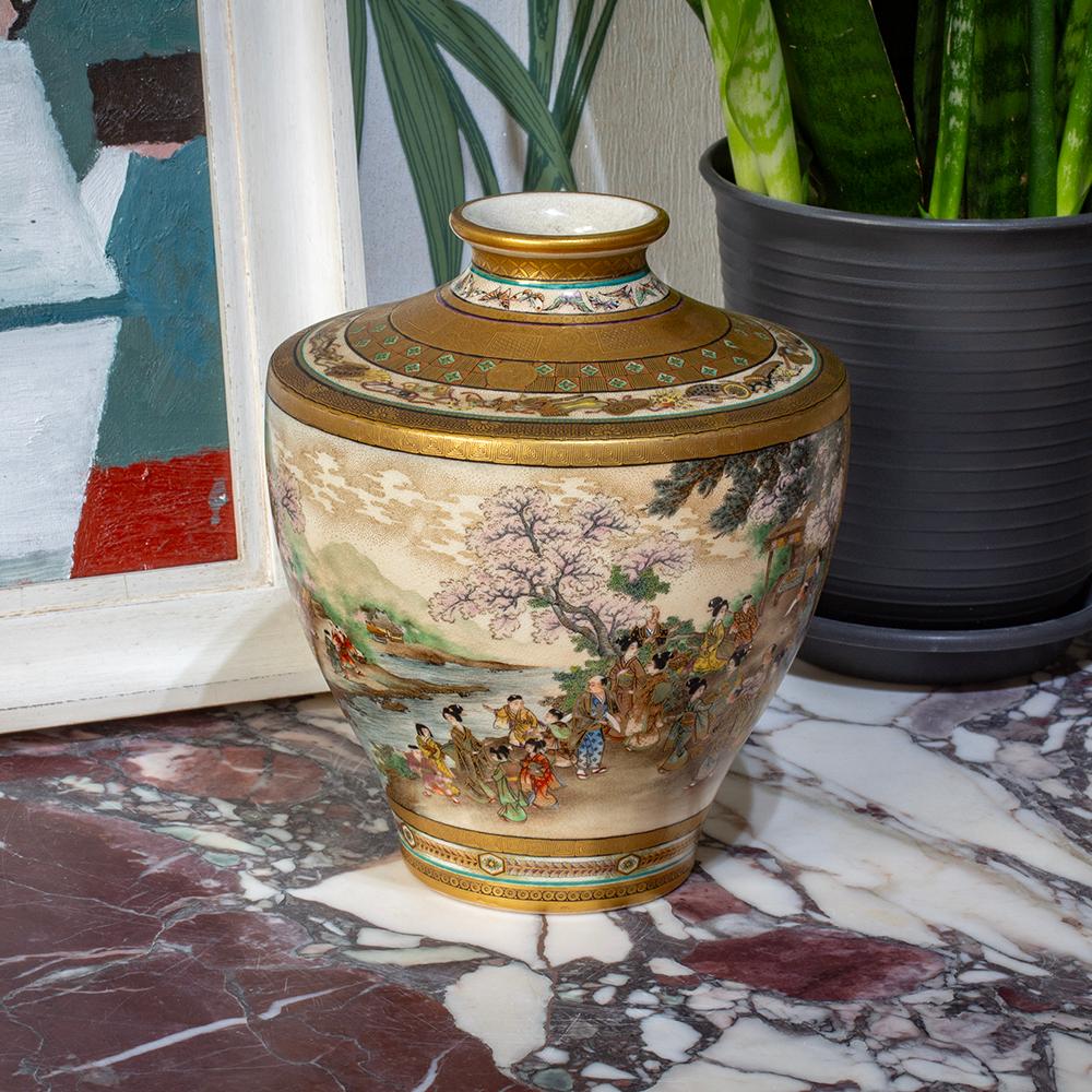The vase of slightly bulbous form potted with a tapered body reaching a slightly pinched neck and rolled top rim is beautifully decorated with two large scenes. The first scene features a mountainous region with a river flowing through the centre