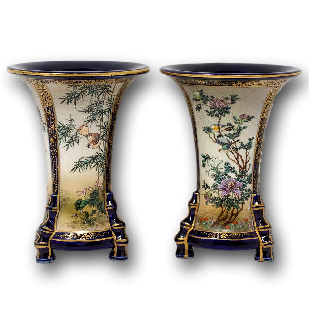 Japanese Meiji period satsuma vase pair. The opposing pair of unusual form with large trumpet mouths and tapered bodies with tripod feet in the form of simulated bamboo. Each pair decorated with the distinctive Kinkozan panelled scenes with