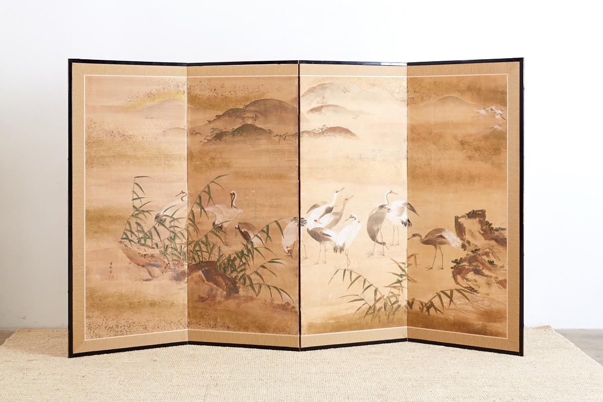 Impressive Japanese four-panel Meiji period screen depicting a landscape scene with cranes. Colorful green pigments with later gold leaf specks decorate the screen. Signed and sealed on bottom left. The screen has a rich texture and color palette