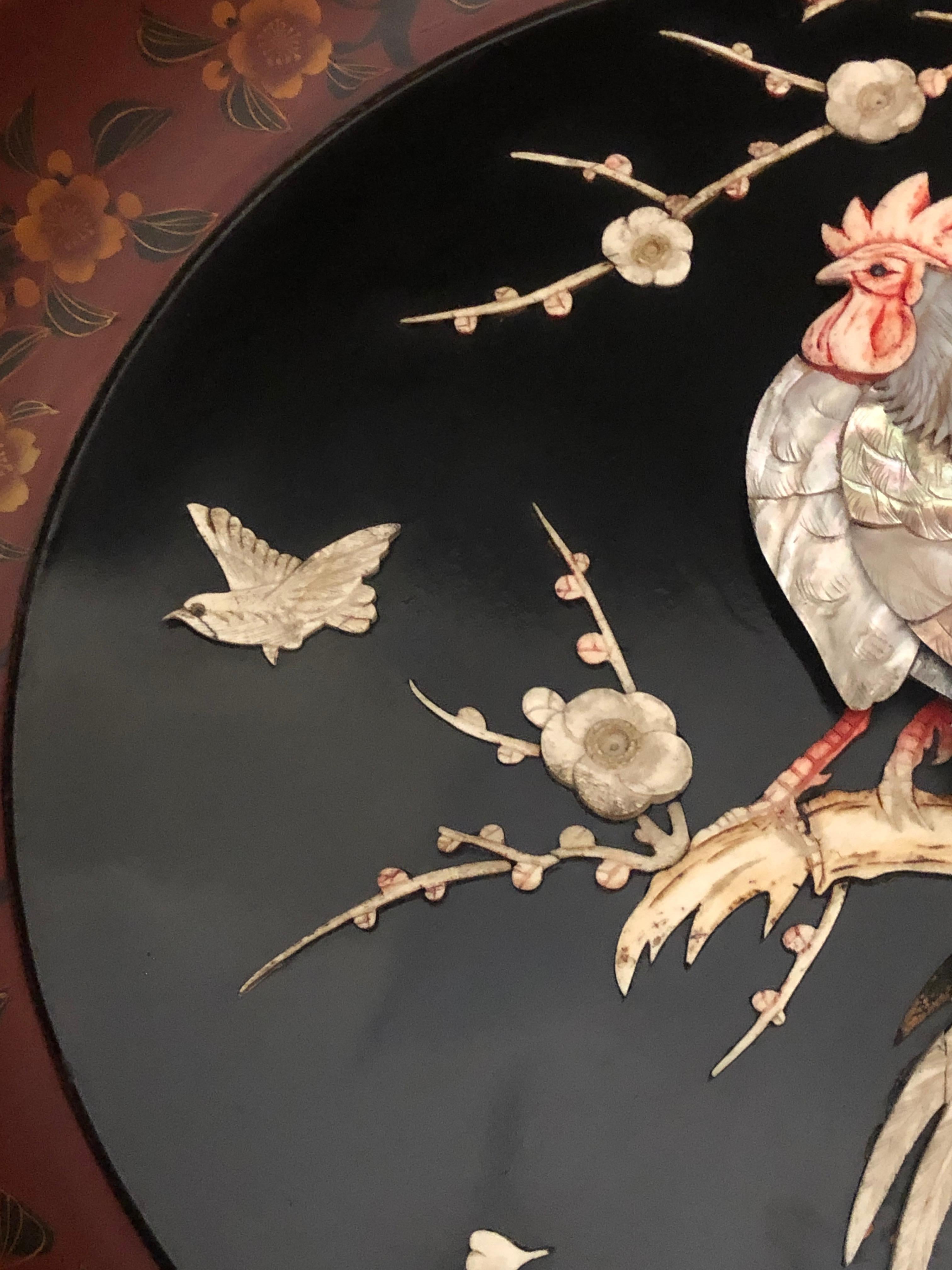 19th century Meiji period charger with cockerel beautifully realised in layers of carved shell, mother of pearl and bone to stand in high relief against the black lacquered ground. Presented in the original red lacquered round frame also painted