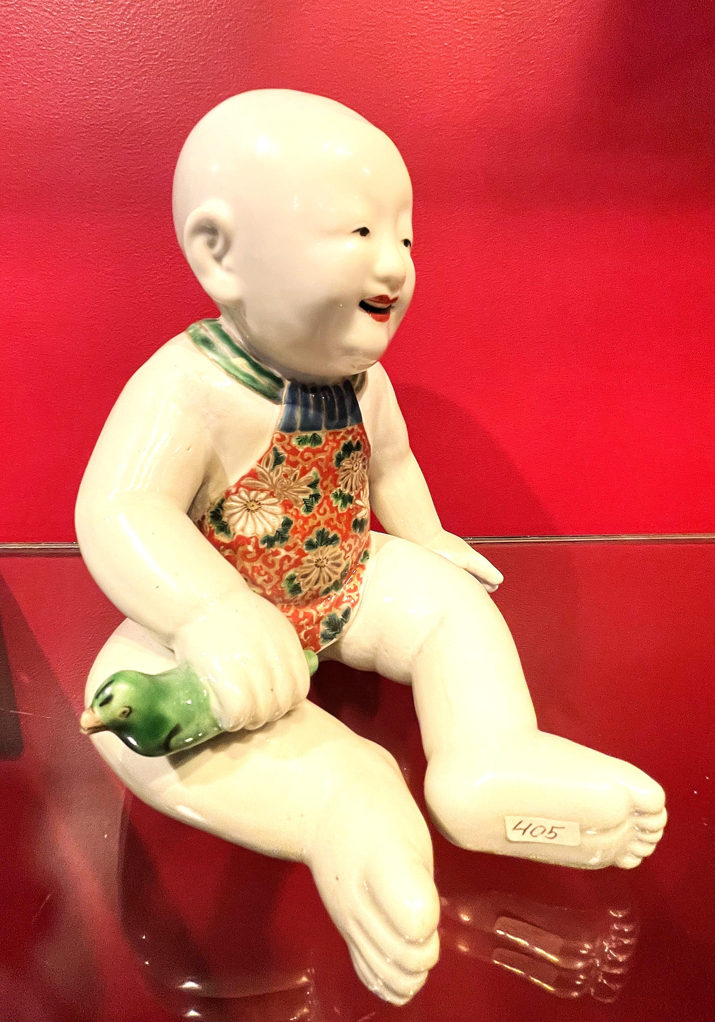 Japanese Meiji Porcelain Figurine of Boy Holding a Green Whistle Bird, Ca. 1890 In Good Condition For Sale In New York, NY