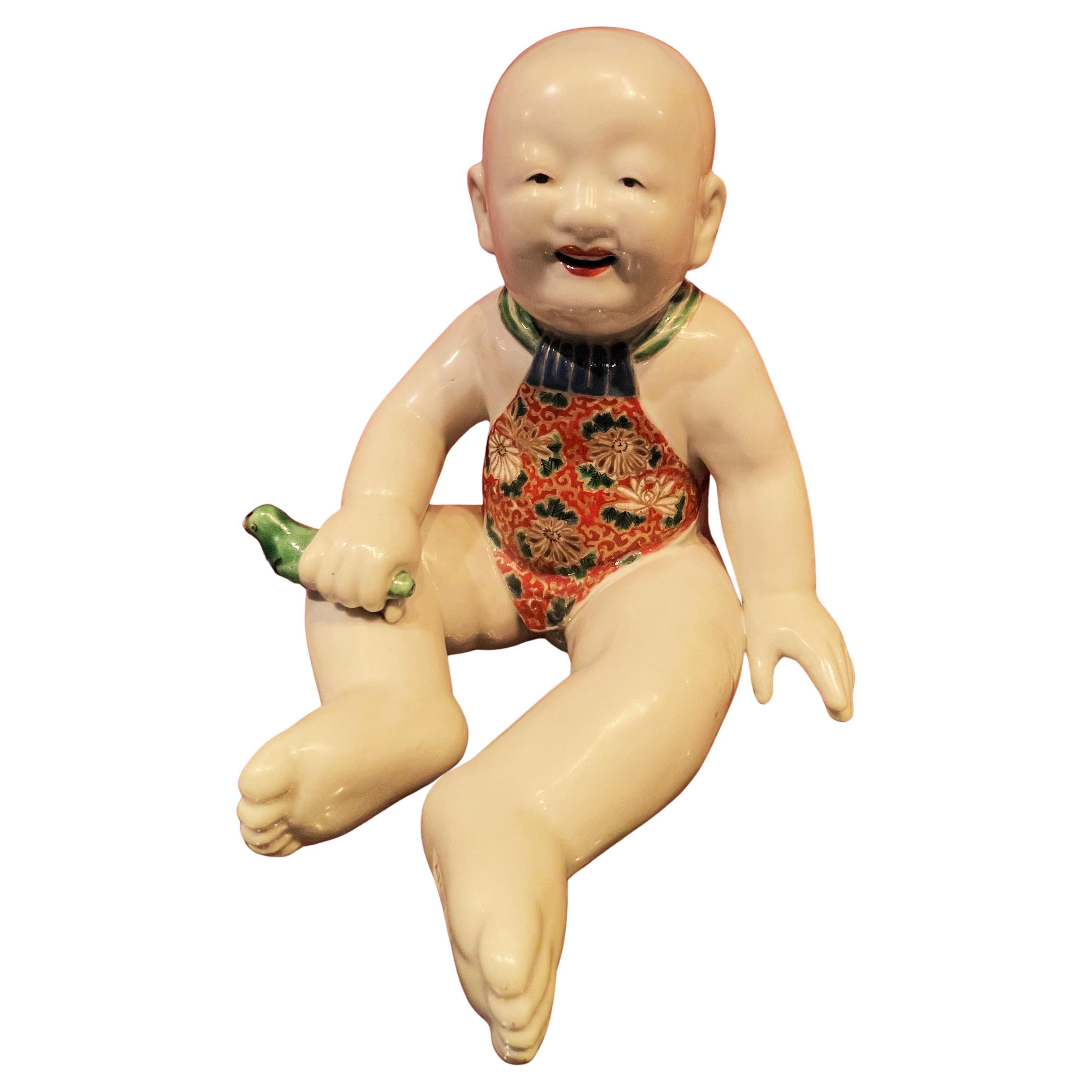 Japanese Meiji Porcelain Figurine of Boy Holding a Green Whistle Bird, Ca. 1890 For Sale