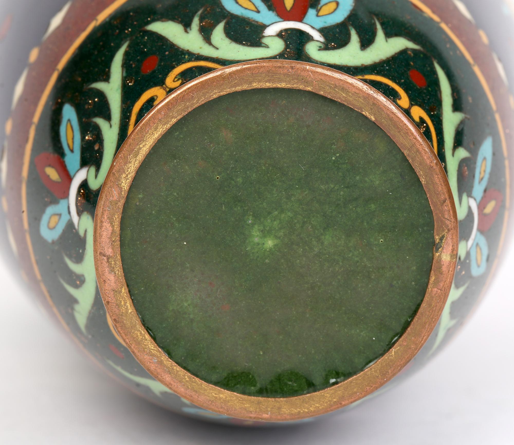 A fine stylish Japanese Meiji cloisonne vase decorated with scrolling leaf and floral patterns dating between 1868 and 1912. The tall elegant bulbous shaped vase stands on a narrow rounded foot and has a large central panel decorated with scrolling