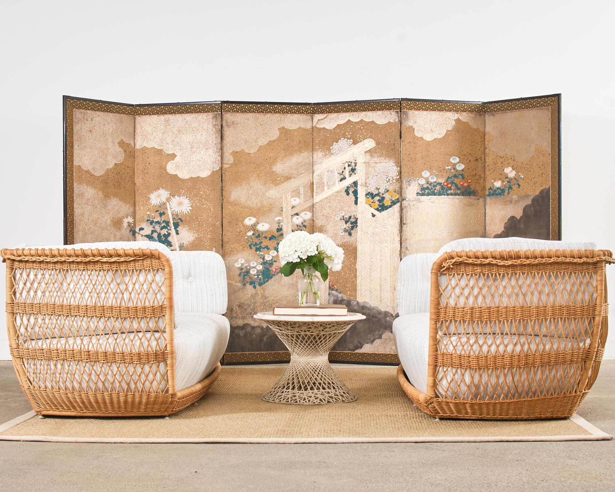 Gorgeous Japanese early 20th century Meiji period six-panel byobu screen featuring a brushwood gate and fence with flowering chrysanthemums. The large screen is crafted with ink and vibrant natural color pigments on mulberry paper. The screen is