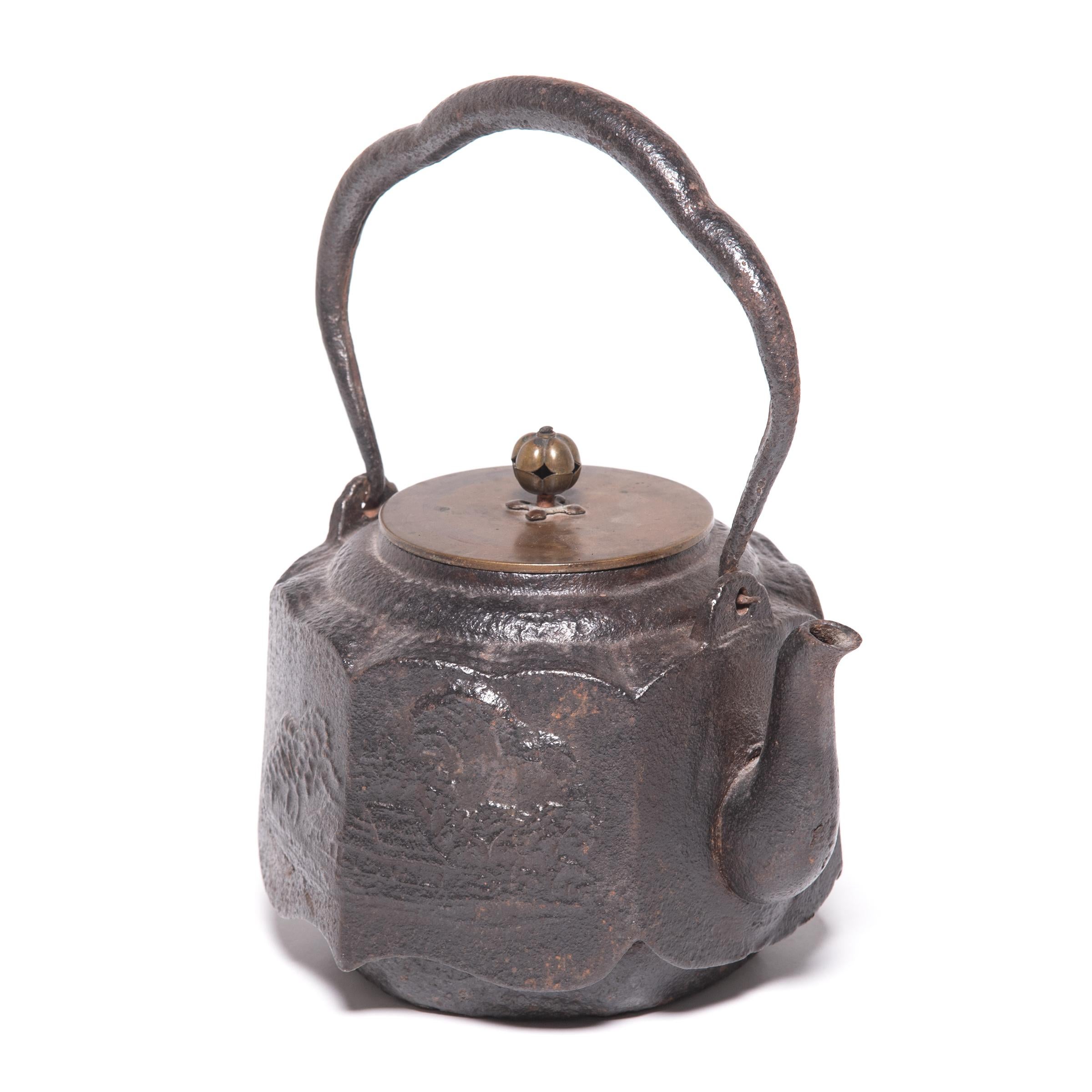 Decorated with an irregular, textured surface and an elegant, arched handle, this Japanese teapot was used to boil water for traditional tea ceremonies. Known as tetsubin, the kettle’s cast iron construction is said to change the quality of the