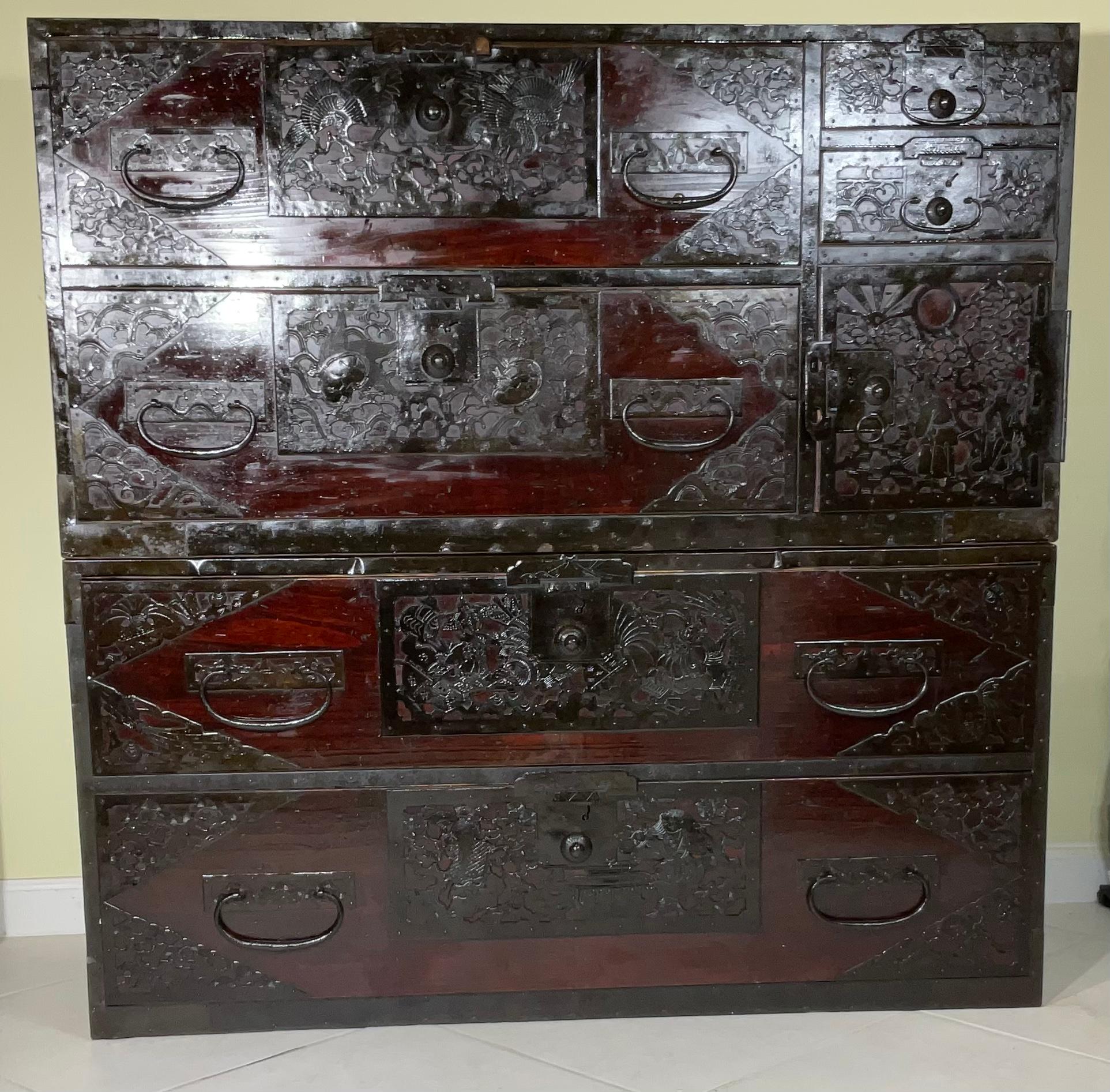 A Japanese Meiji two-part tansu chest from the mid 19th century, with Metal hardware of hand etching, vivid motifs of Woman birds turtles and even one bunny This wooden chest is a fine example of Japan's traditional mobile cabinetry. Featuring a