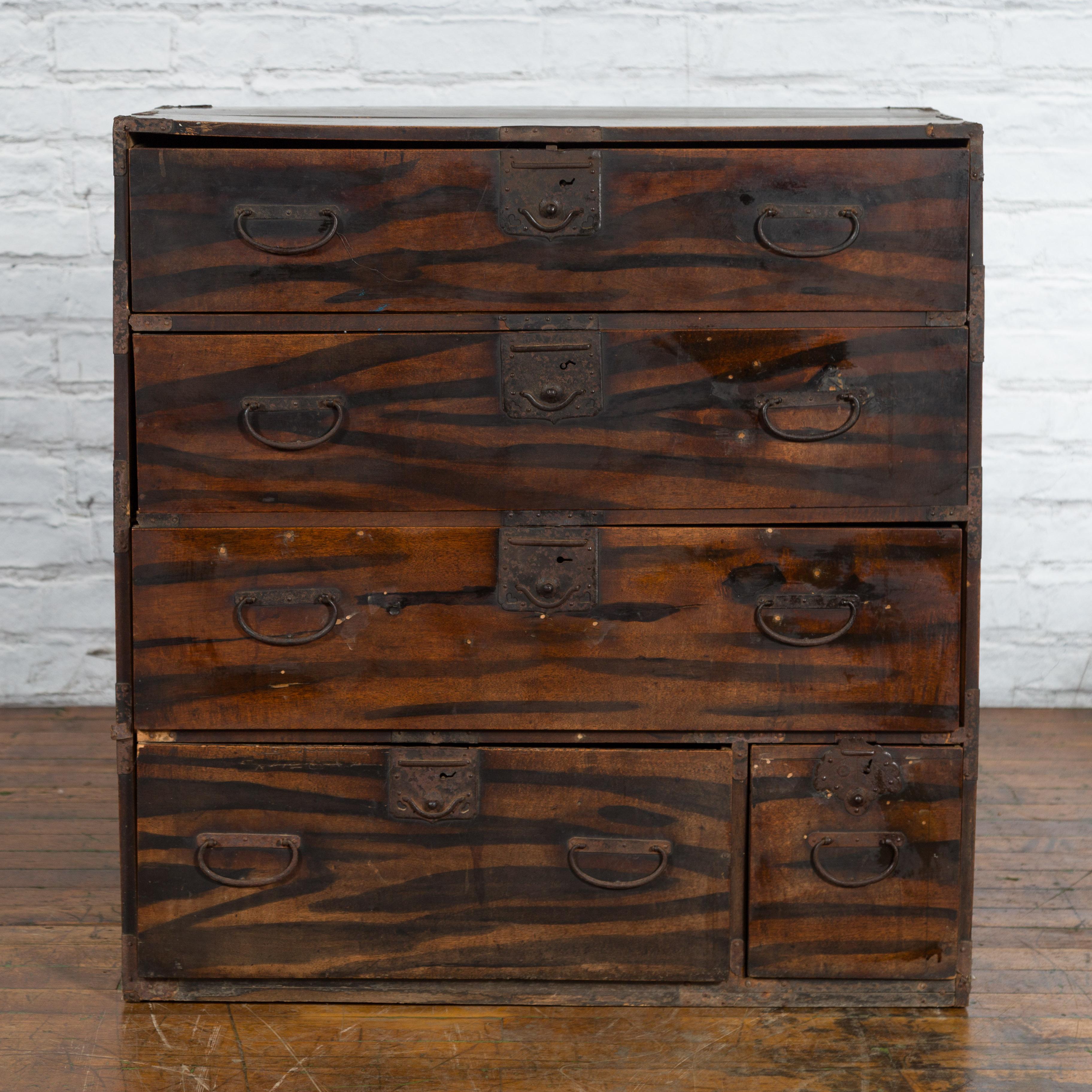 A Japanese Meiji period single section tansu clothing chest from the late 19th century in Isho-dansu style, with zebra wood, five drawers and carrying handles. Created in Japan during the Meiji period in the later years of the 19th century, this