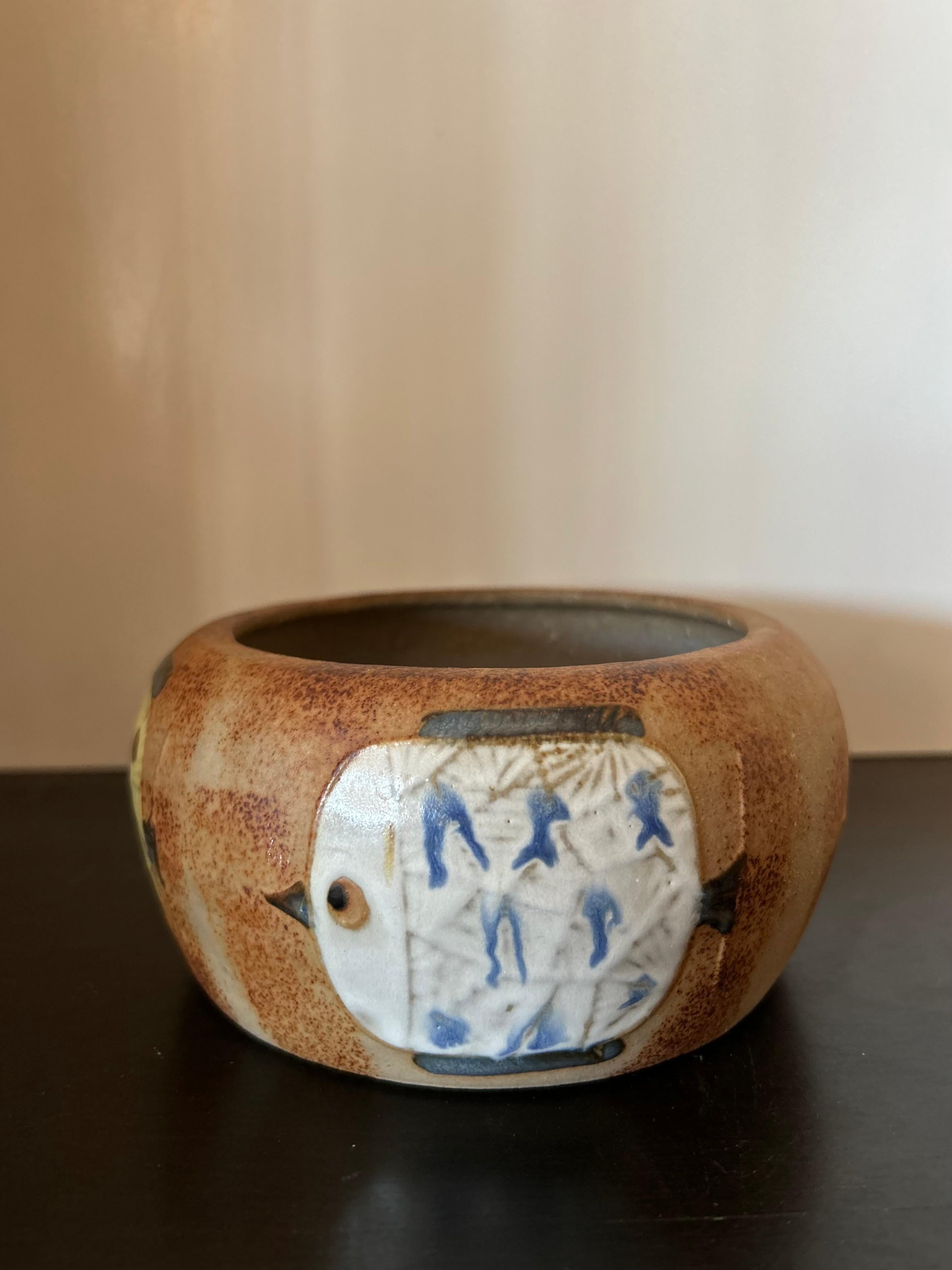 Decorative mid-century ceramic bowl from Japan with glaze painted yellow and white fish.