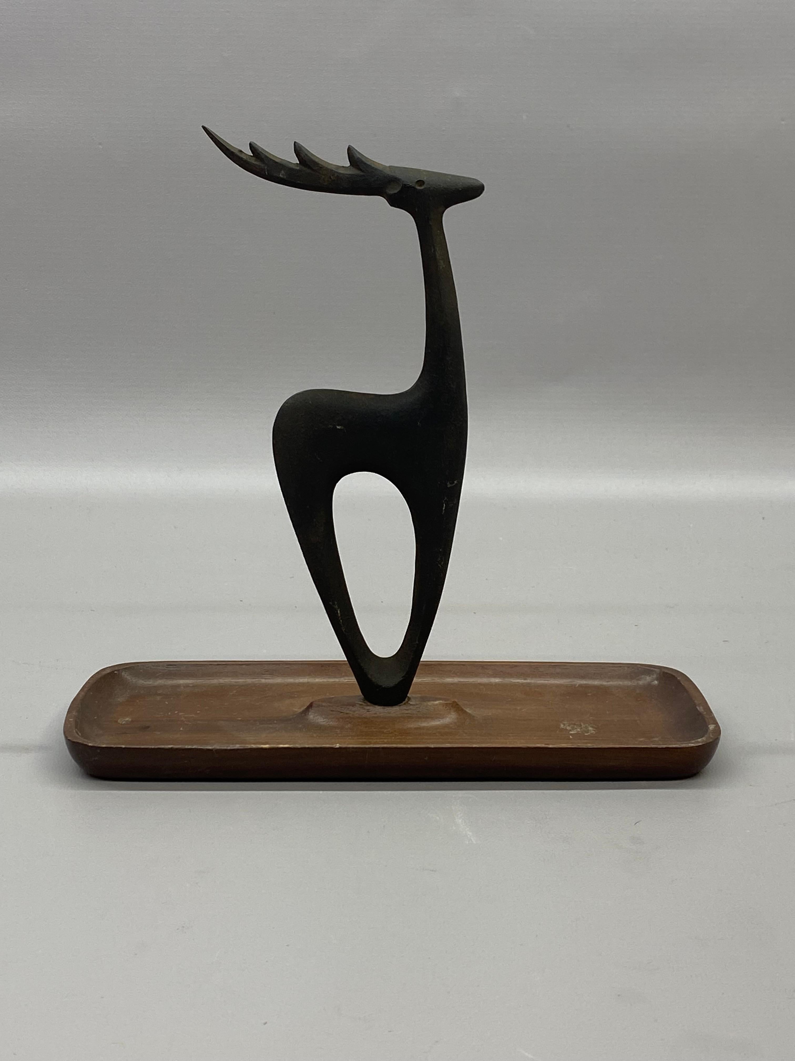 Decorative stylized Japanese ironware deer on a wood base designed by Tadahiro Baba. Gold stencil mark on the bottom of base, Yashica. Tadahiro's designs usually are utilitarian be it a corkscrew, bottle opener, paperweight or bookends. This piece