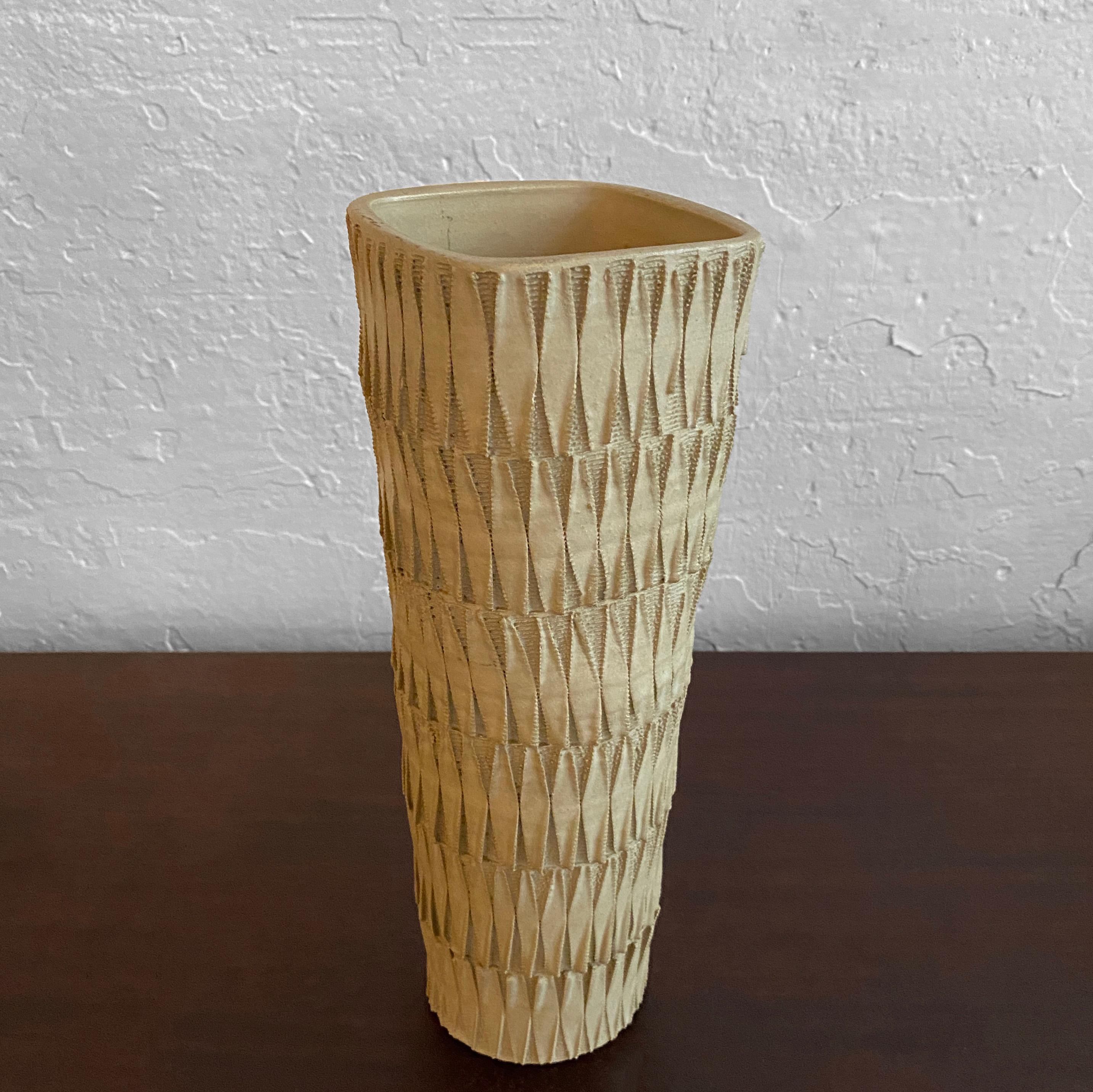 Interesting, midcentury, Japanese, matte tan, earthenware, art pottery vase features a tapered body, intricately carved and incised in a leaf pattern with Japanese markings on it's underside.