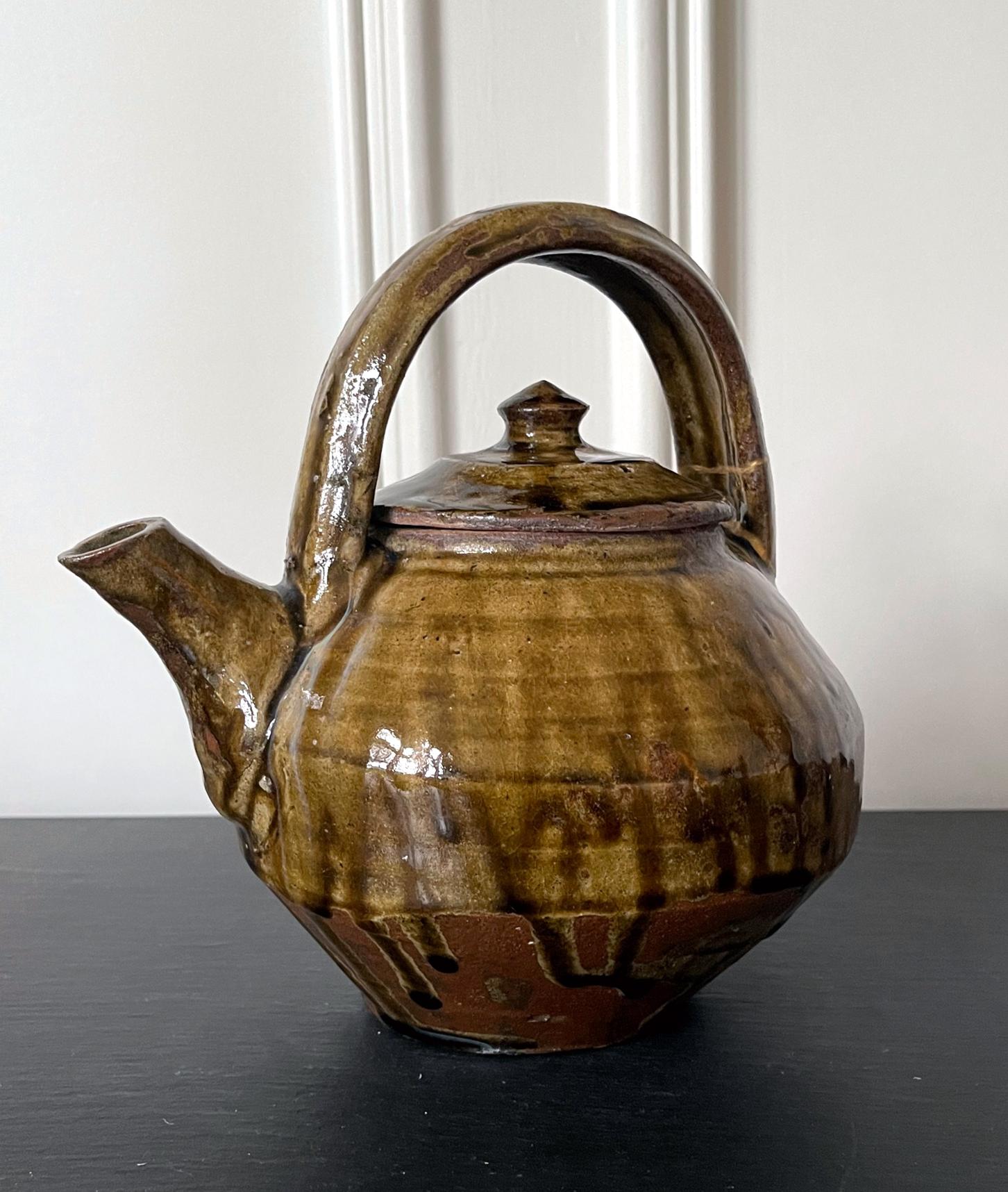 Japanische Steingut-Teekanne von Hamada Shoji (japanisch 1894-1978), ca. 1960-80er Jahre. Die Teekanne hat eine klassische Form und einen starken Mingei-Stil (Volkskunst). Sie war mit einer dicken Nuka-Glasur (Asche aus Reisspelzen) überzogen, wobei