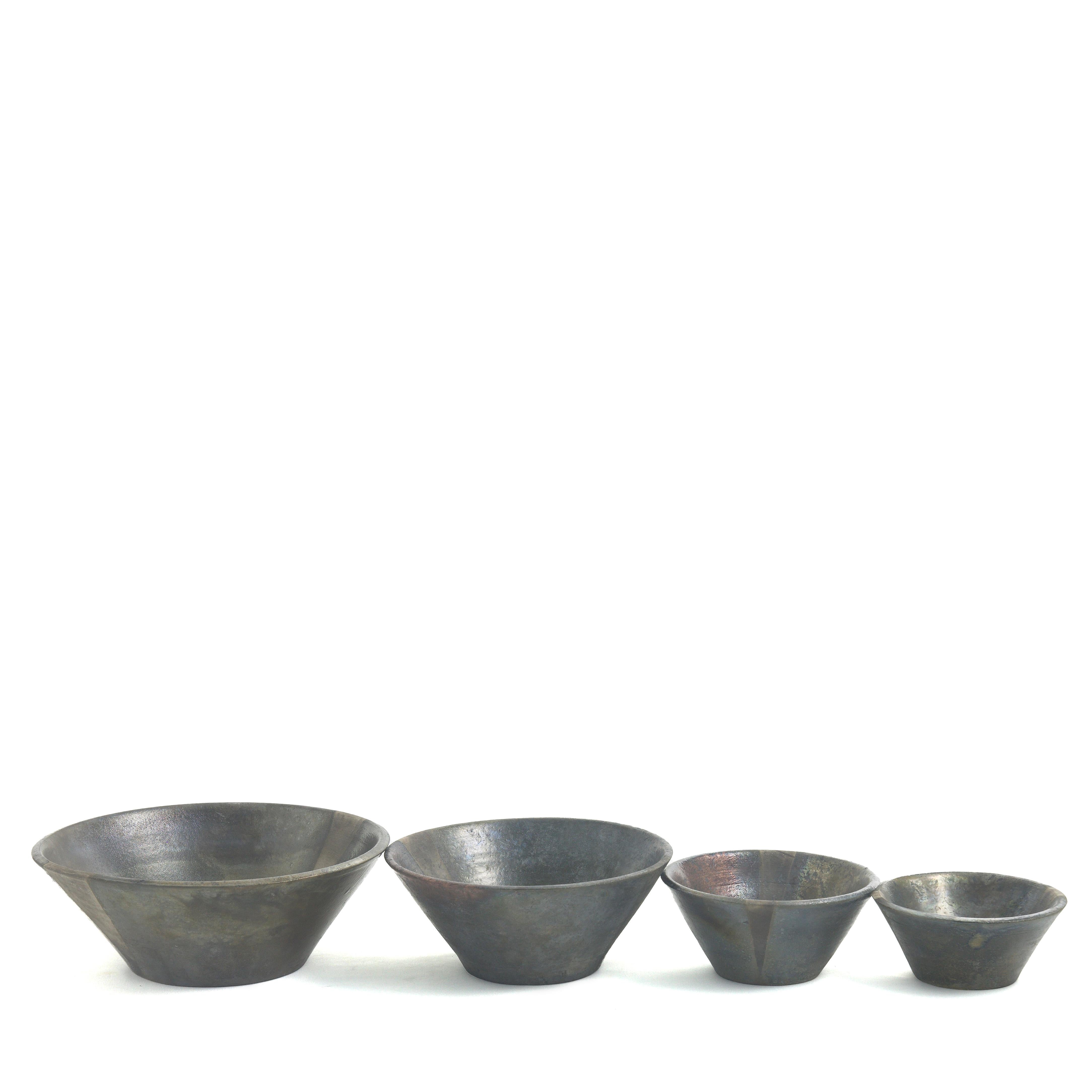Blackfringe Set Of 4 Bowls

Defined by a bold and clean-lined silhouette, the four bowls composing this set handcrafted from Raku-style ceramic echo the refined charm of Japanese pottery. Their dark appearance is brightened up by metallic