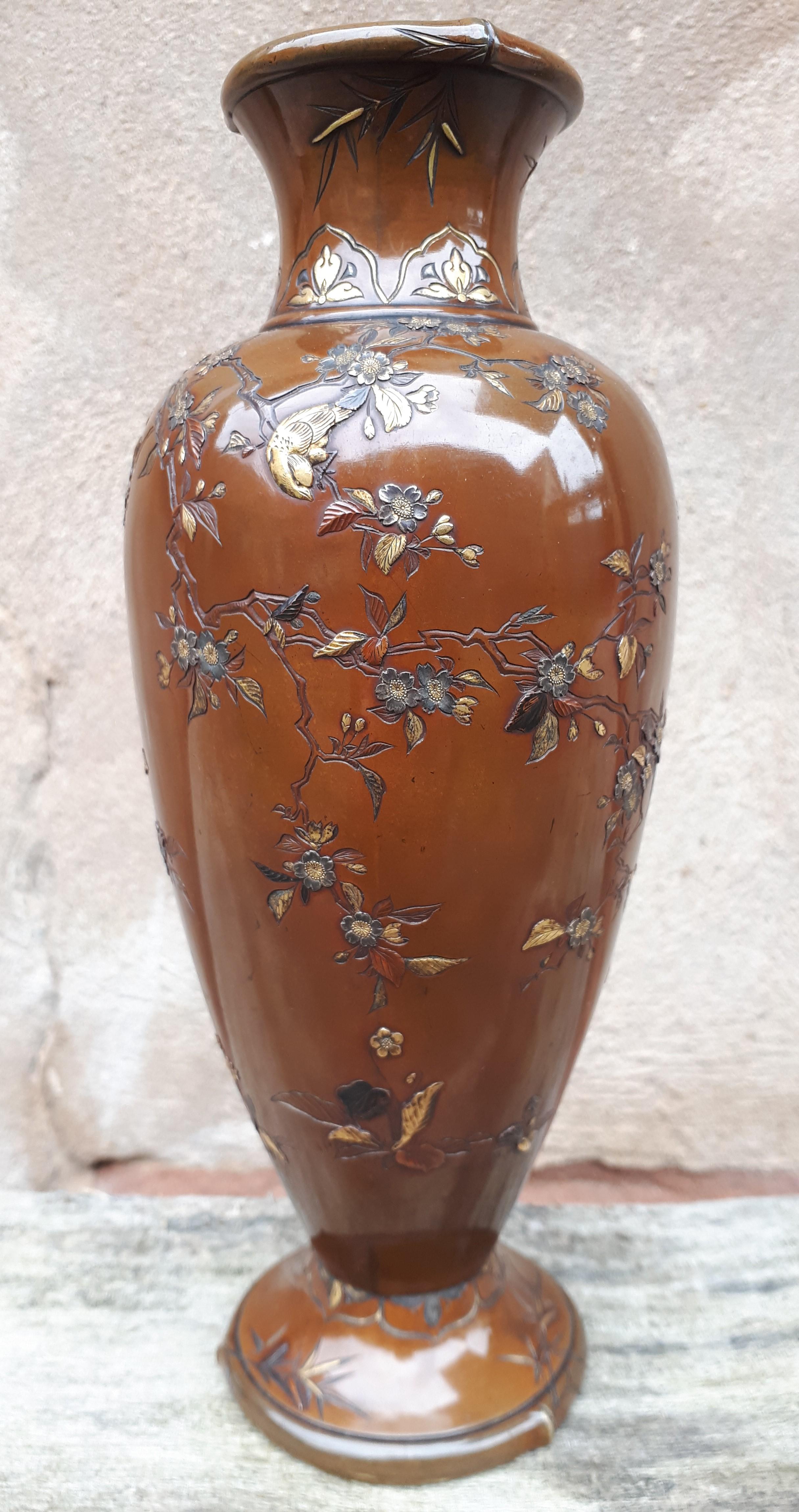Bronze vase with inlaid decoration of birds and butterflies among cherry blossom branches, the neck and base with bamboo motif. The inlays are in hira and taka zogan in gold, silver, shakudo and sentoku. Signed Inoue zo in a cartouche on the