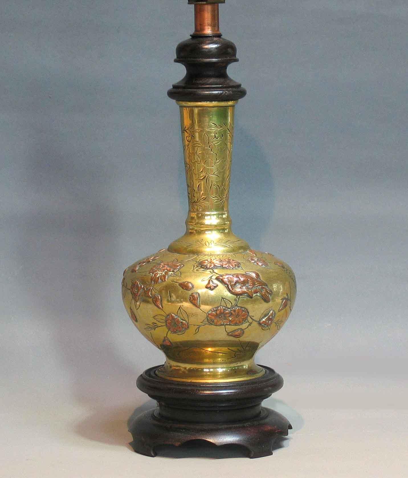 Japanese mixed metal vase
Mounted as a lamp
Meiji period

The bulbous-form body with long conical neck
decorated in high-relief copper with a sparrows
perched on a branch of various flowering plants.
Mounted on a wood base and wood collar on