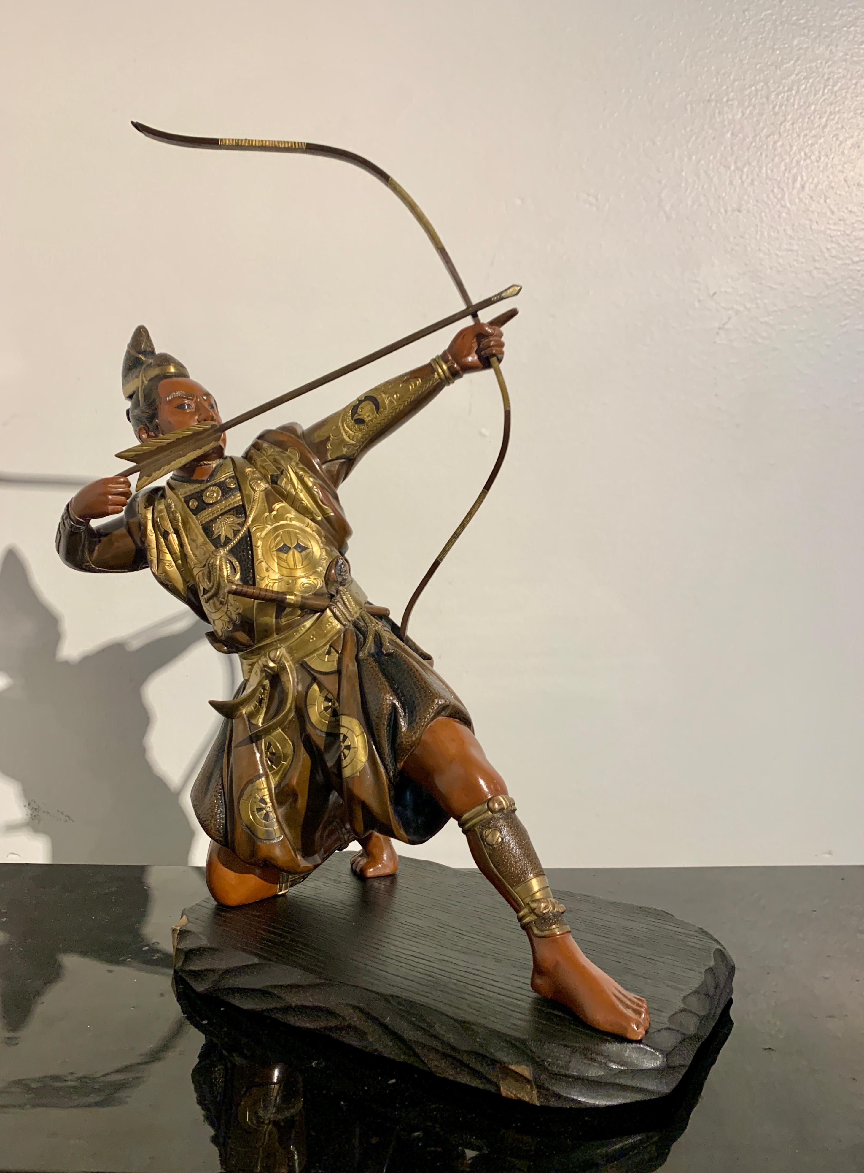 A spectacular Japanese cast, carved, and parcel gilt bronze sculpture, okimono, of a kneeling samurai archer, signed Kiyotsugu (died 1894), Meiji Period, circa 1880, Japan.

The bold and dramatic sculpture depicts a kneeling samurai archer with