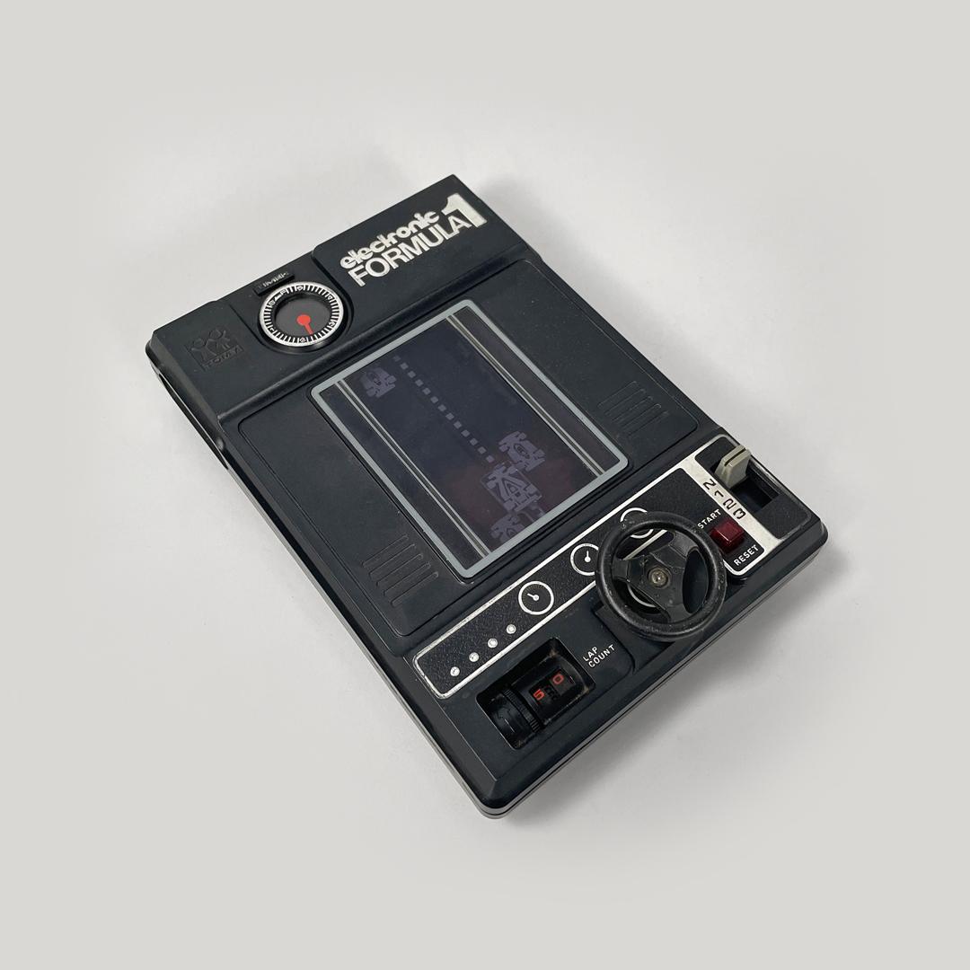 Japanese modern black plastic videogame Formula 1 by Tomy Electronic, 1978
Electronic game or video game mod. Formula 1 rectangular in black and silver plastic. On the front there is the screen, on the bottom there are the black plastic buttons with