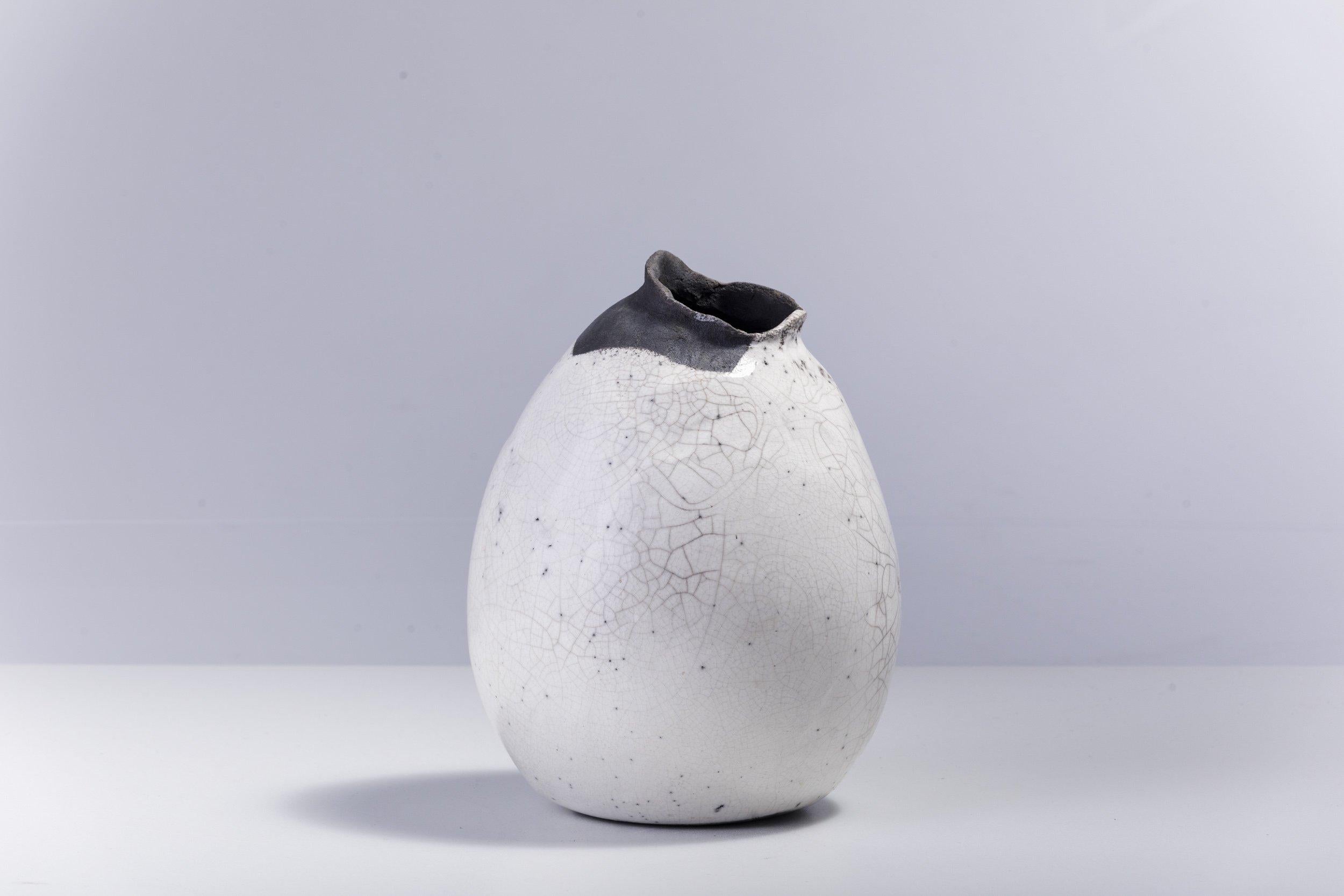 Impermanenza noire

Témoignage unique de l'artisanat, ce magnifique vase sculptural se distingue par un bord irrégulier, dentelé et de couleur noire, résultat de l'étonnante technique de cuisson Raku d'origine japonaise. Sa forme bombée en