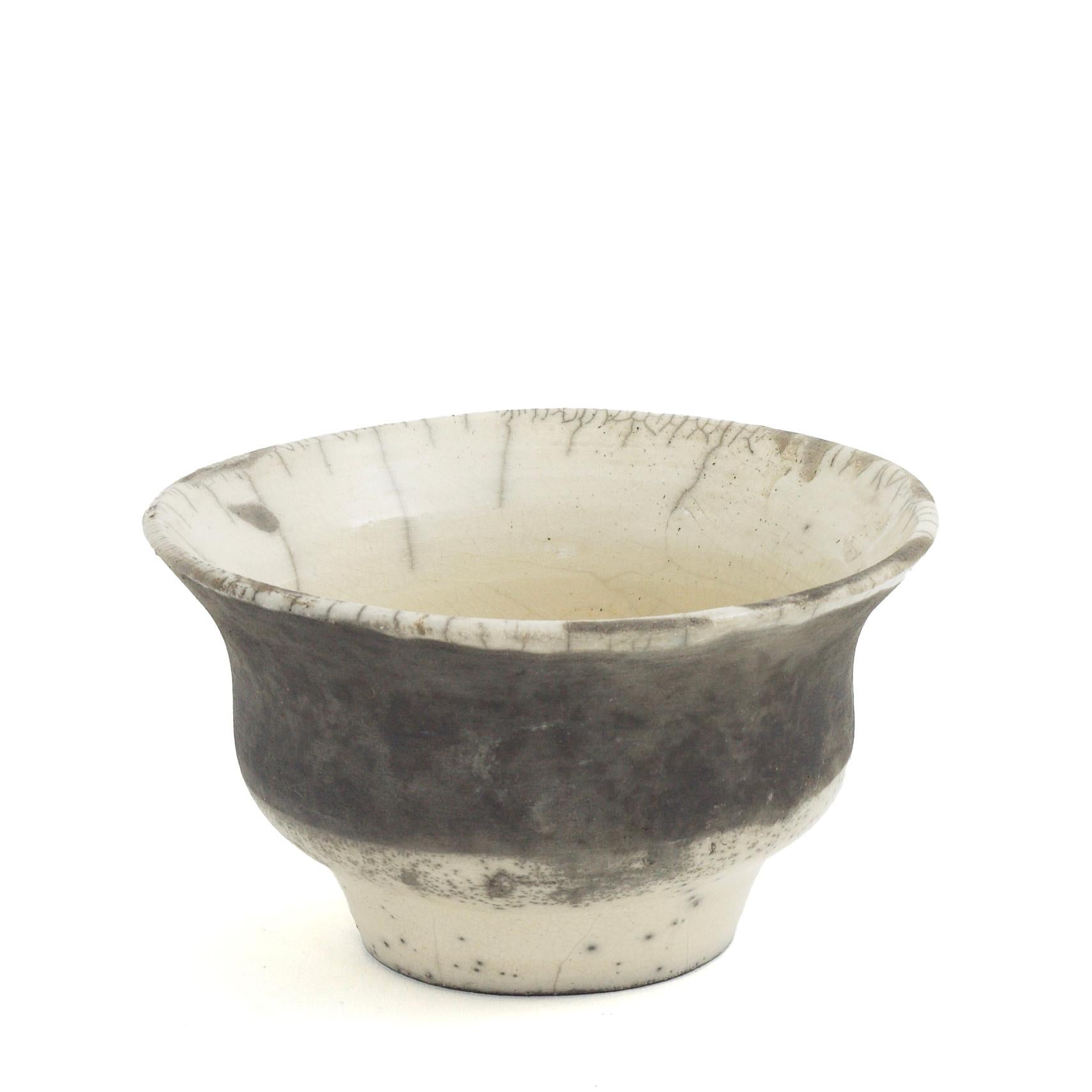 Patto-Vase

Diese einzigartige Vase mit ihren geschwungenen Kurven und dem ausgestellten Profil wurde in Handarbeit aus Keramik nach der alten japanischen Raku-Töpfertechnik hergestellt, was zu einem unverwechselbaren Craquelé führt, dessen