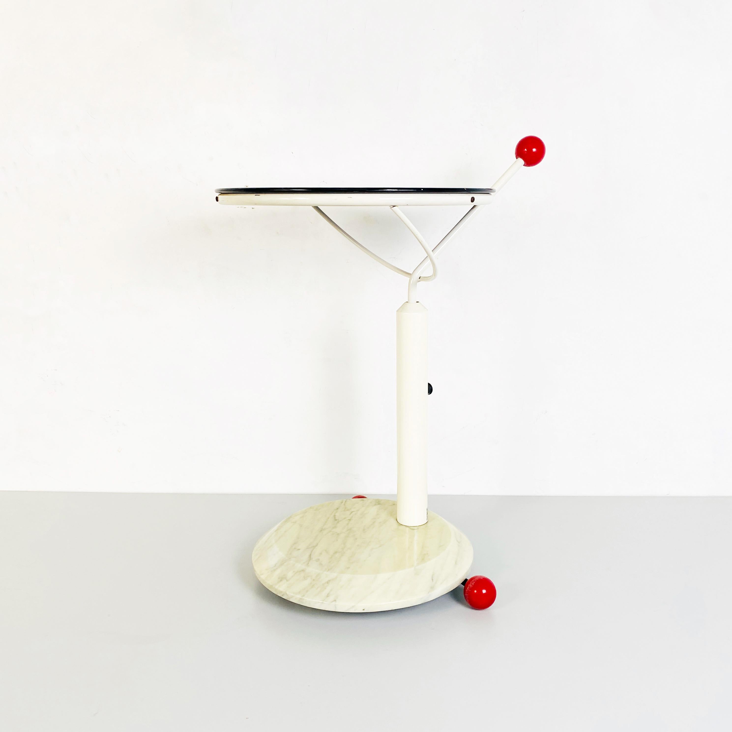 Marble and metal cart with wheels, 1980s
Cart with wheels composed of a white marble base, red plastic wheels, white metal structure and swivel top in black painted wood. There is a handle with a plastic knob to move it easily that bears the mark