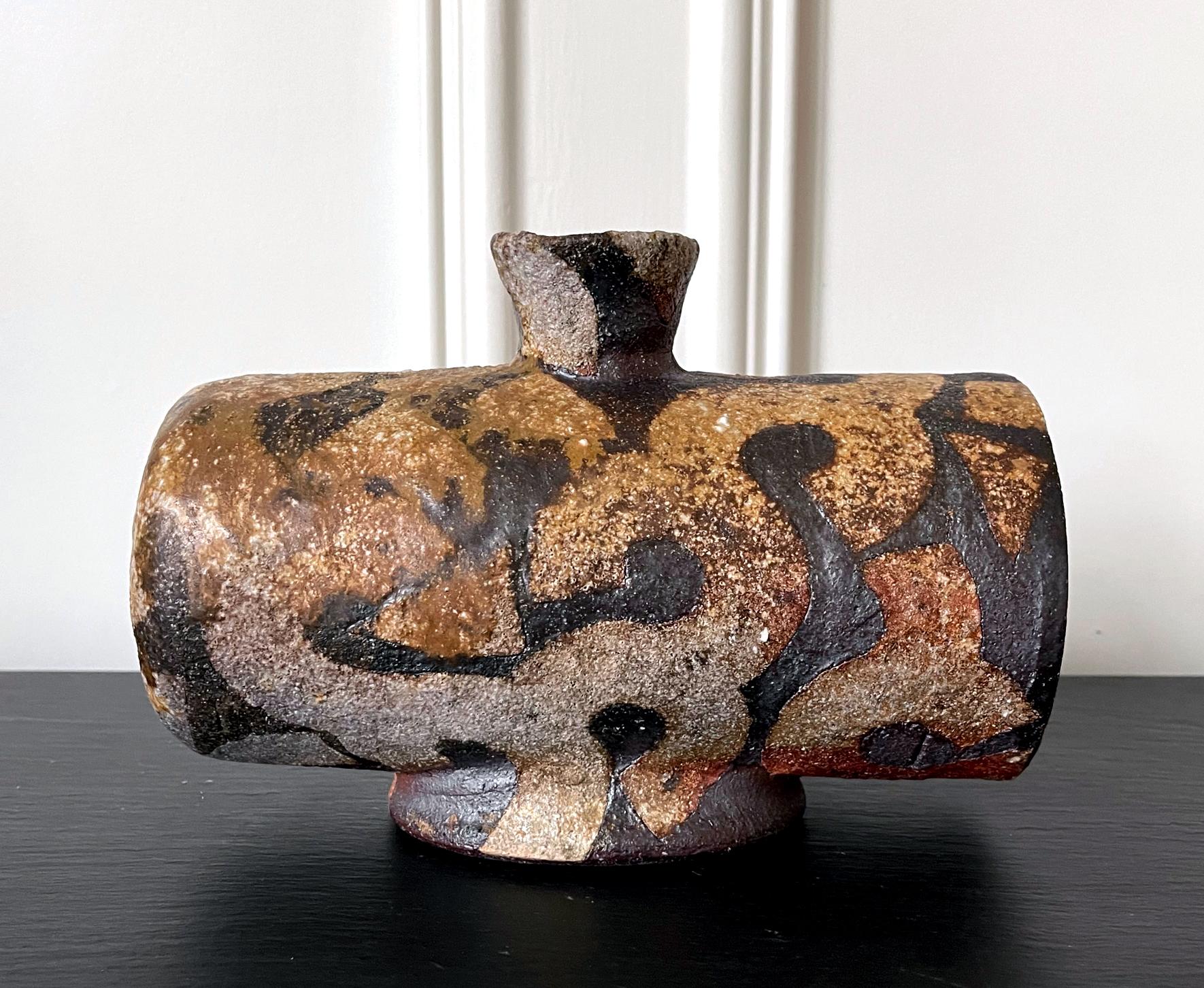 An unusual zogan stoneware vase by potter Takauchi Shugo (Japanese, b. 1937) circa 1980-1990s. The vase strikes an unusual horizontal form with a barrel shape body supported by a short oval foot ring and opens to a small upright short-necked mouth.
