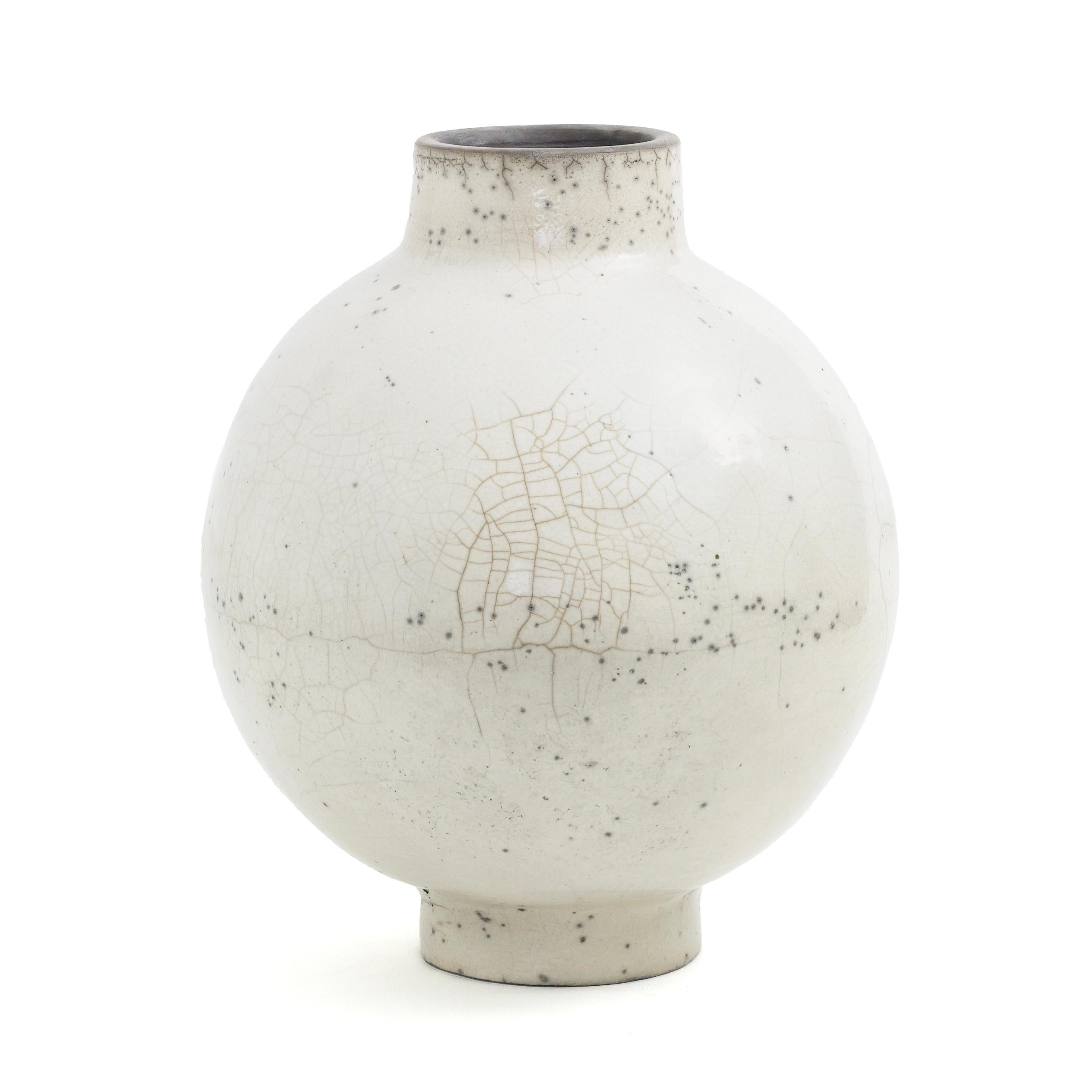 Dome L vase

A bulging body marked by generous curves and enlivened by tiny dark speckles defines this exquisite ceramic vase, whose characteristic, delicate cracks result from a deft application of the Japanese ancient Raku technique. The