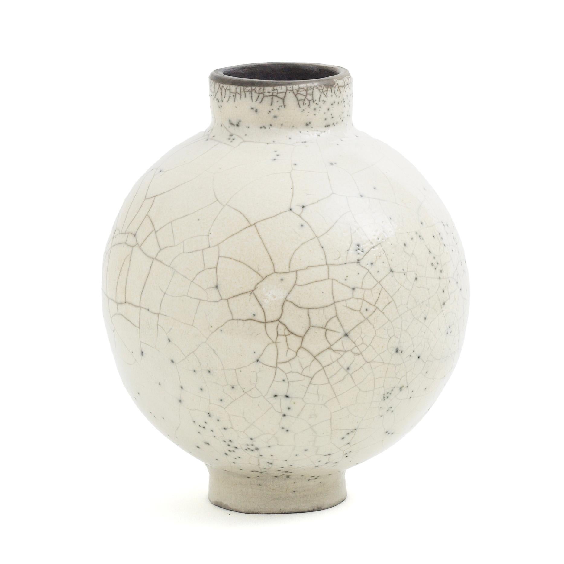 Dome vase

Singular, unpredictable cracks and tiny speckles distinguish the captivating aesthetic of this vase, featuring a cylindrical base and mouth incorporated within the spherical body. Minutely handcrafted of ceramic following the ancient