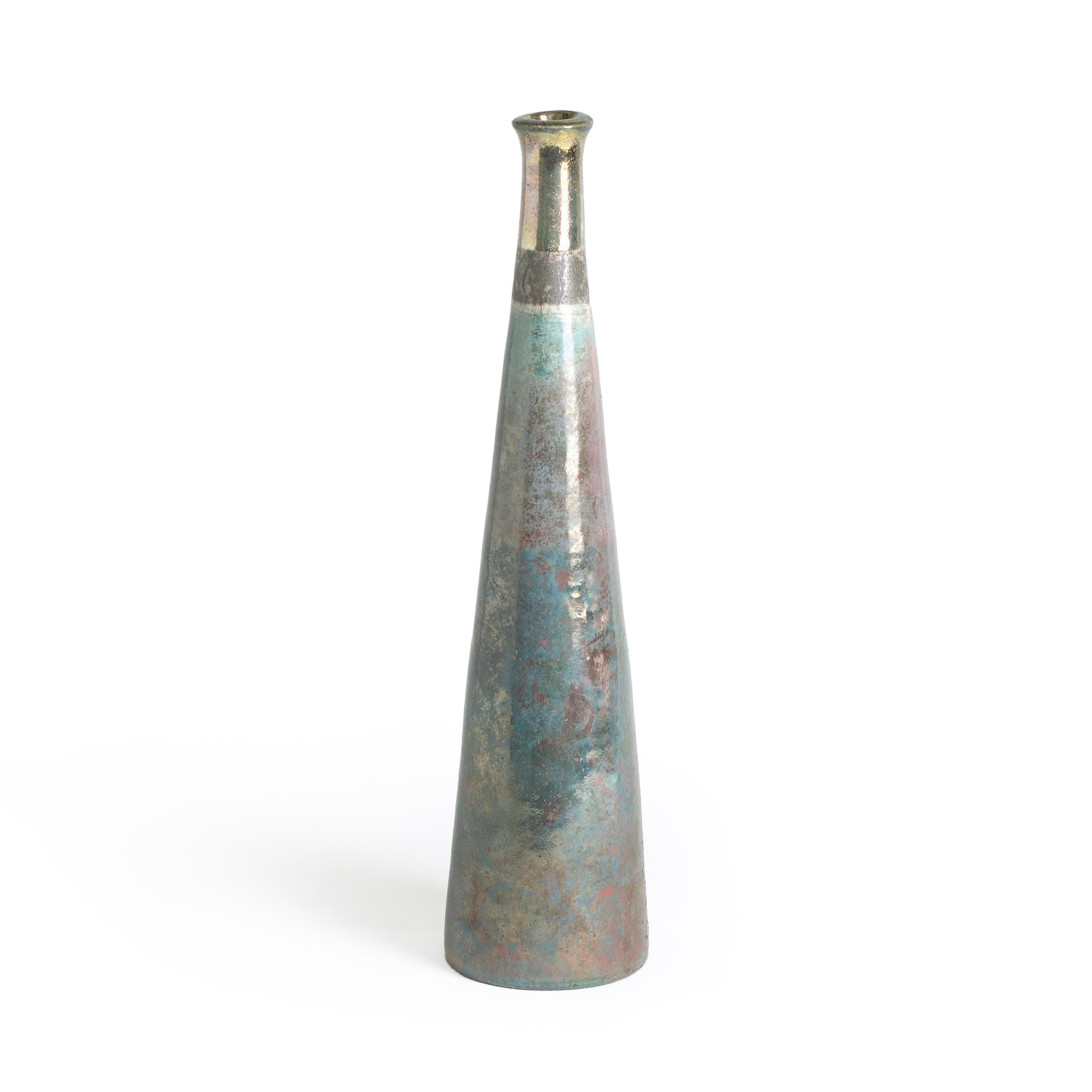A metallic effect cover the body of this tall candle holder ranging from shades of copper green and turquoise to red oxyde iron while the top features a gold finishing realized by a third firing process executed after the Raku firing, showcasing