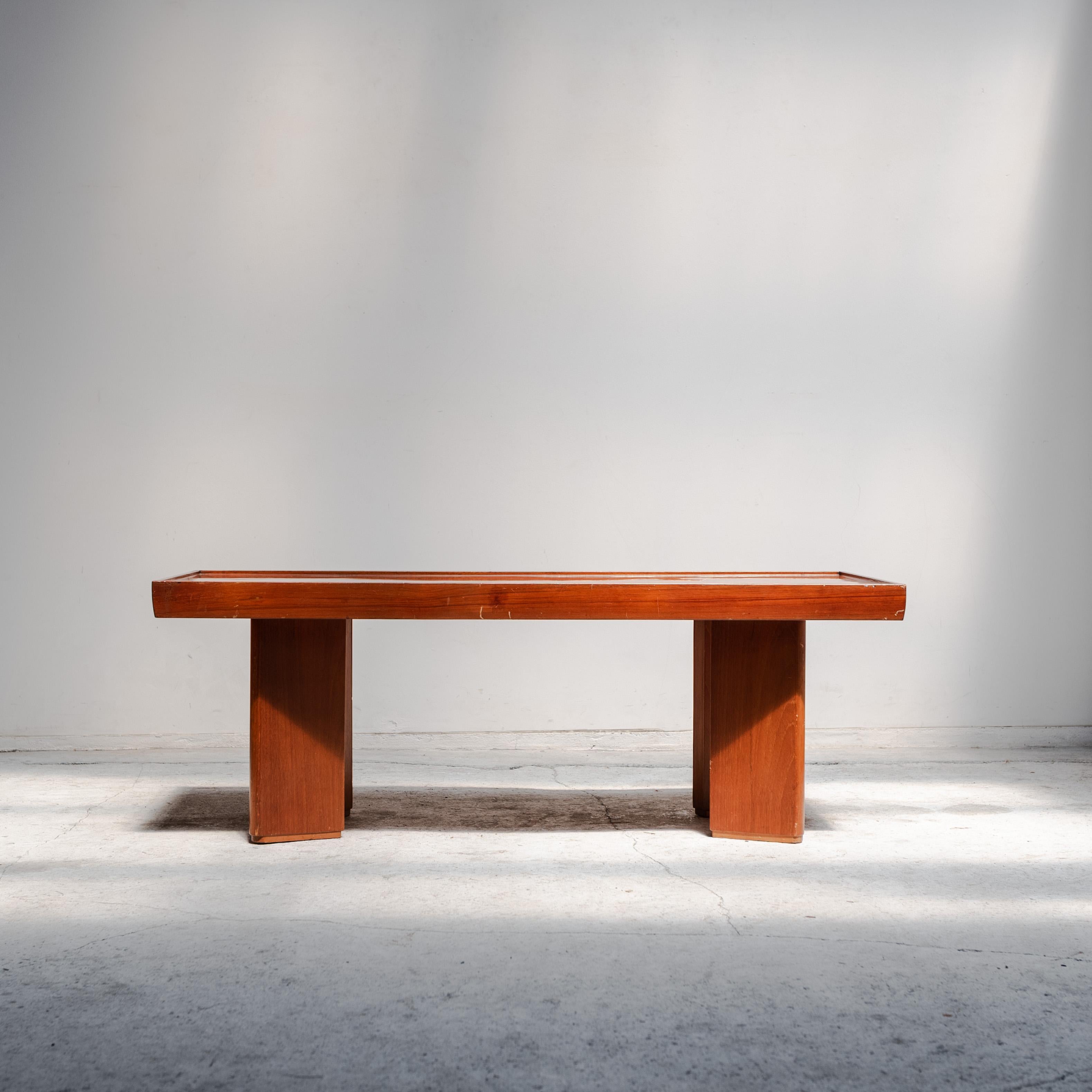 A refined example of Japanese modernist design, this low table reflects the harmony of proportion and material that defined the era. Executed in warm-toned wood with a framed top and architectural legs, it embodies both simplicity and presence — an