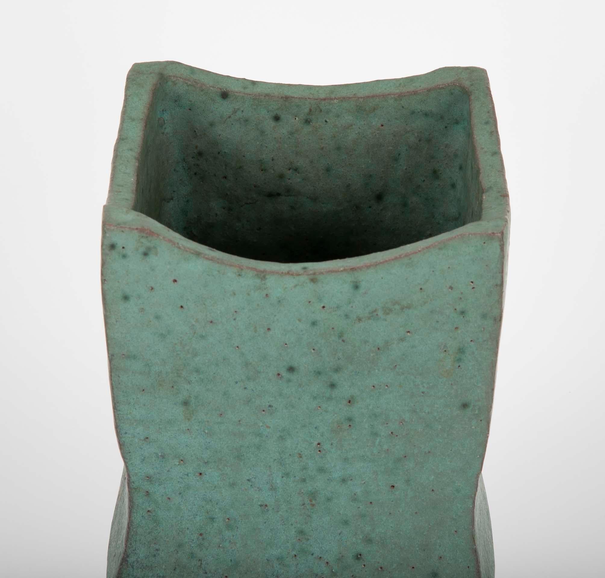 A beautifully conceived, thoroughly modern Japanese ceramic vase with wonderful muted turquoise glaze. The geometric upper portion above a round tapered unglazed base. An unusual and very compelling design. Marked on base.