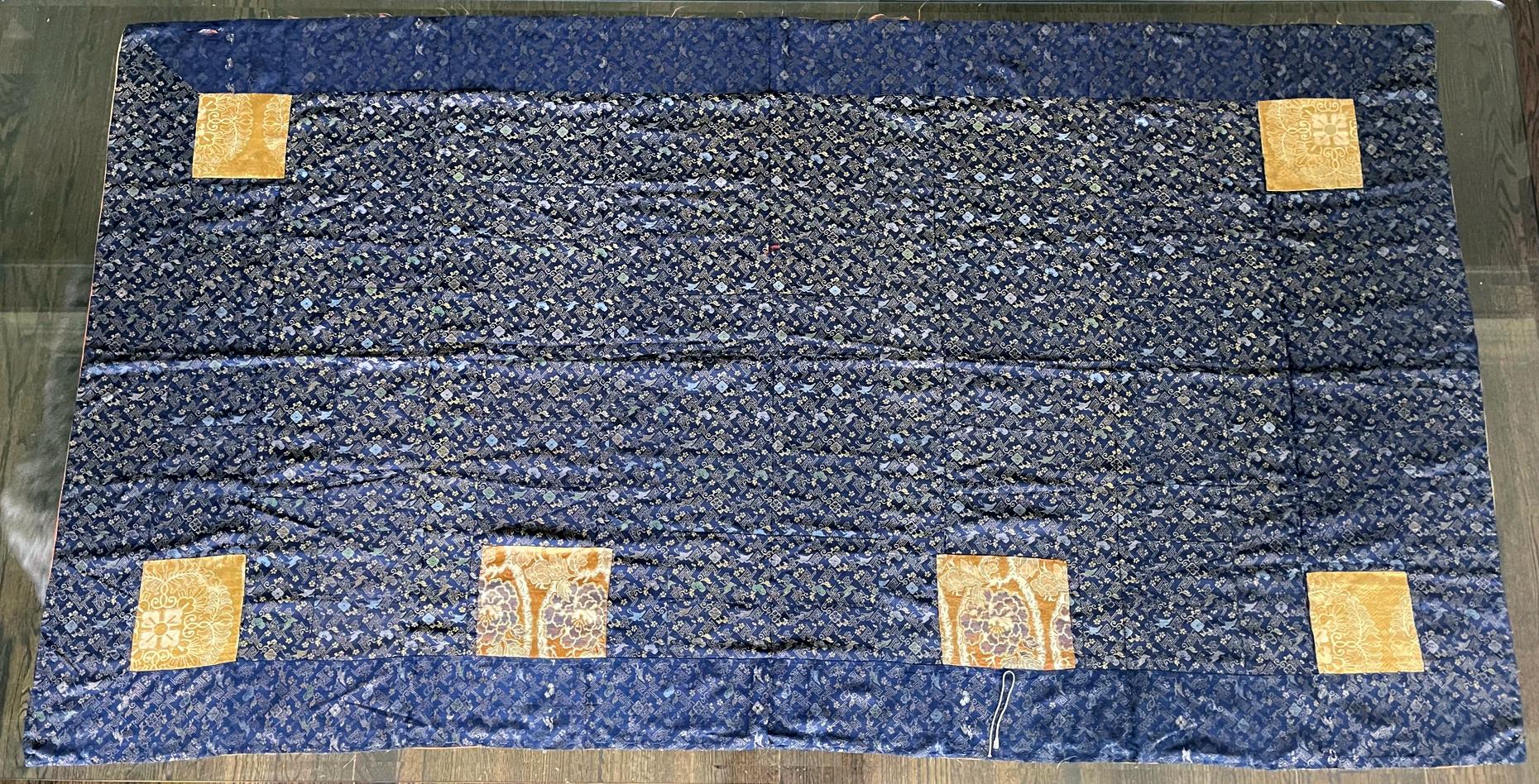 A Japanese Kesa (Monk's Vestment) made from fourteen columns of patchworks of blue brocades with sumptuous woven pattern. The elaborate motifs feature repetitive pattern of flying cranes, hababishi (four petal flowers), paulownia leaves, all