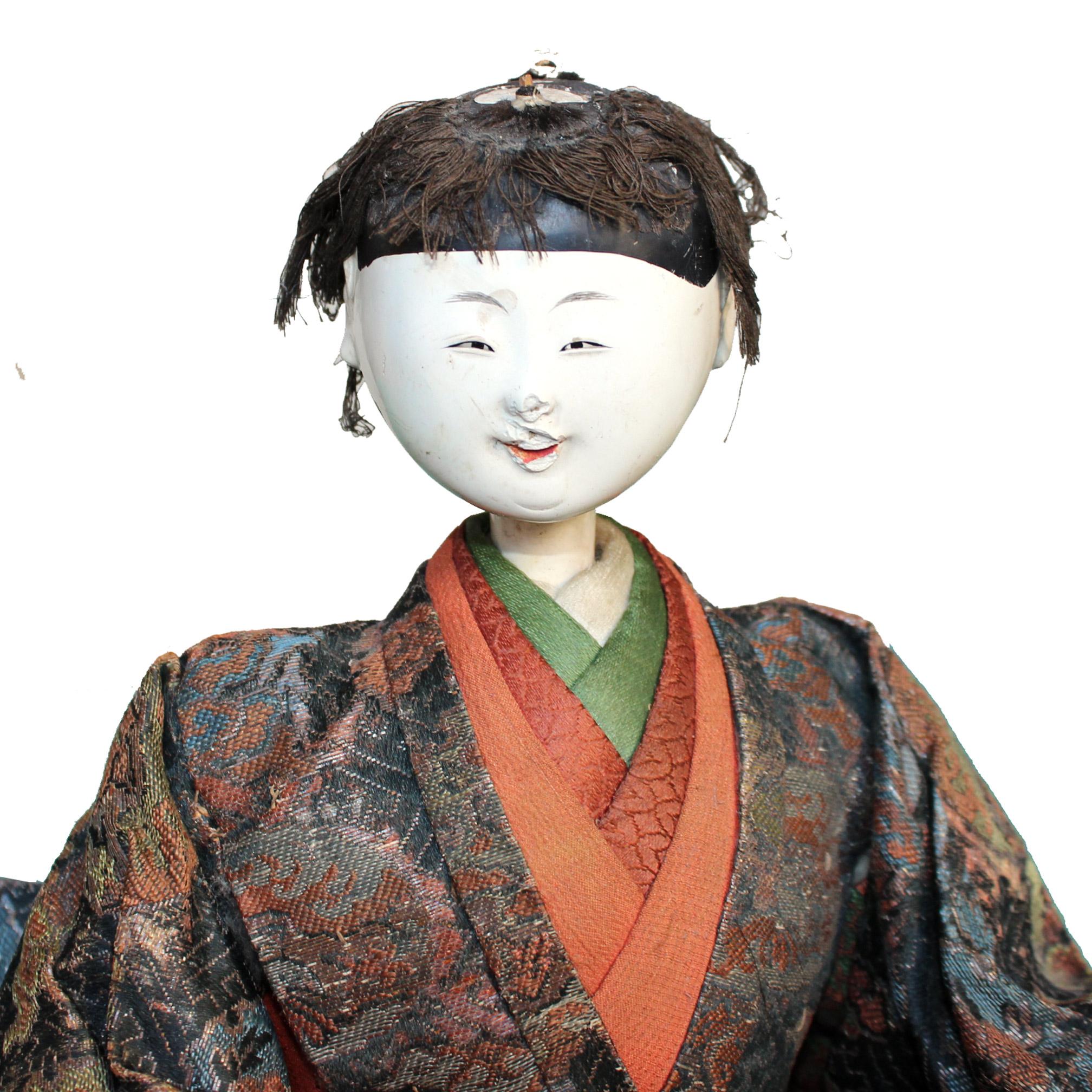 Master artisans skillfully crafted the Kyoto doll with white lacquered wood head and hands, dressed in Classic Japanese style clothes made from antique kimono textiles. Doll depicts one of the musicians in traditional Japanese Noh theatre. Meiji