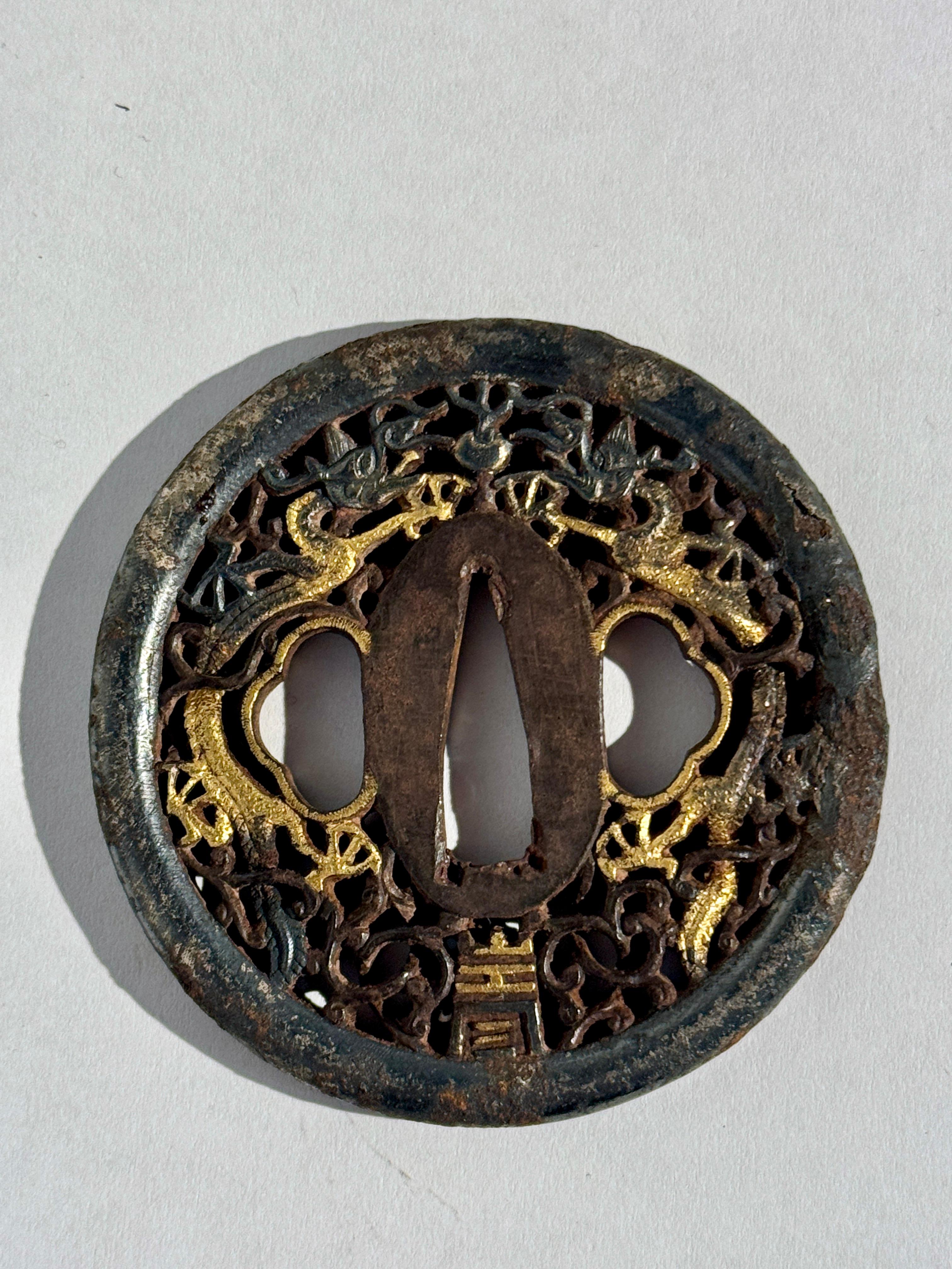 Eine dramatische japanische Eisentsuba im Nanban-Stil, verziert mit Drachen und Durchbrochenem, mit Silber- und Goldeinlagen, Edo-Periode, frühes 19.

Die fantastische Tsuba in runder Form zeigt ein Paar schreibender Drachen, die einen flammenden