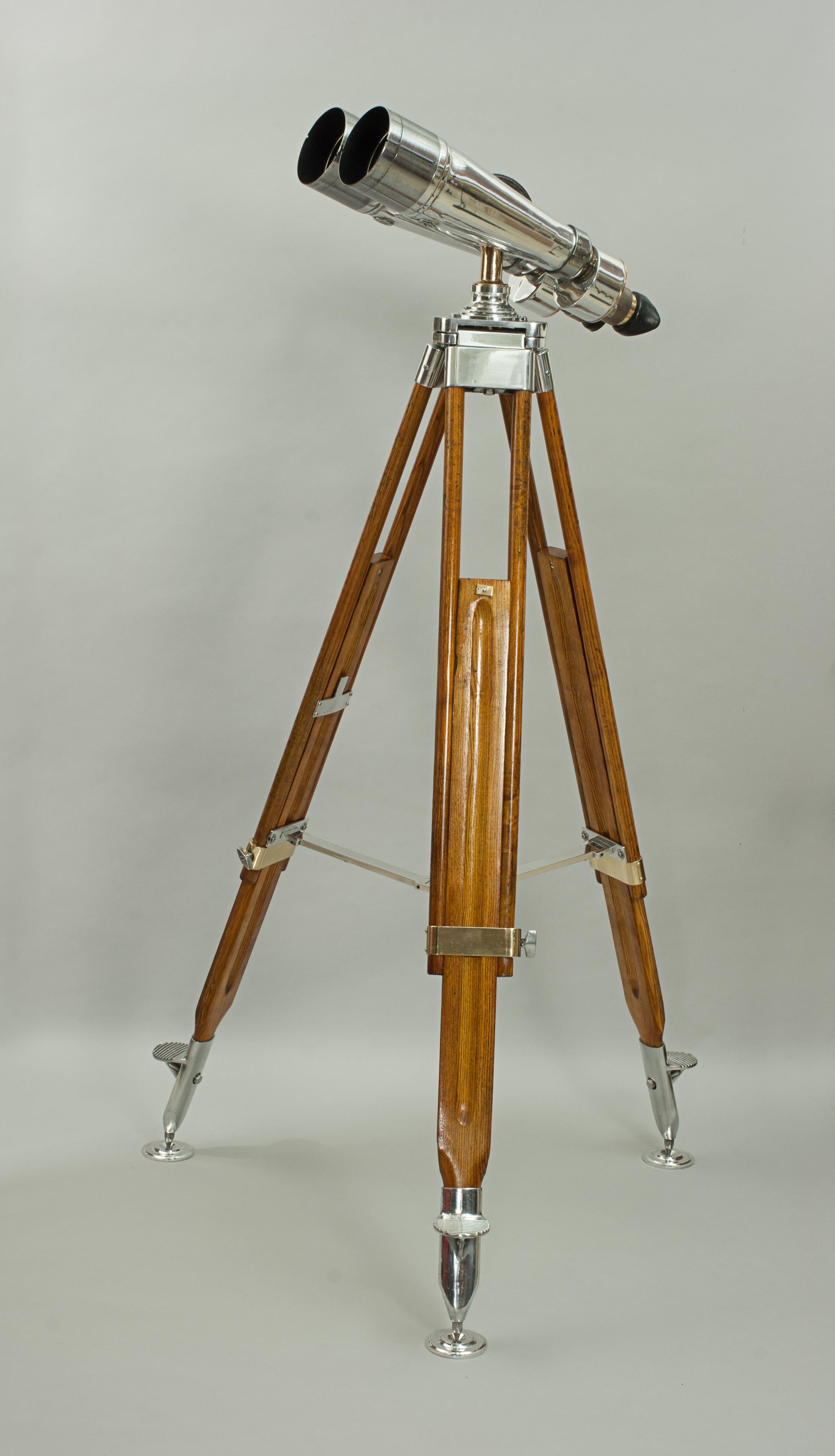 A large pair of Japanese ex-navy observation binoculars mounted on a vintage adjustable wooden Carl Zeiss design tripod. The WWII marine binoculars with 4º incline eyepieces are marked '15 X 4º, TOKO, No. 1731'. These binoculars are predominately