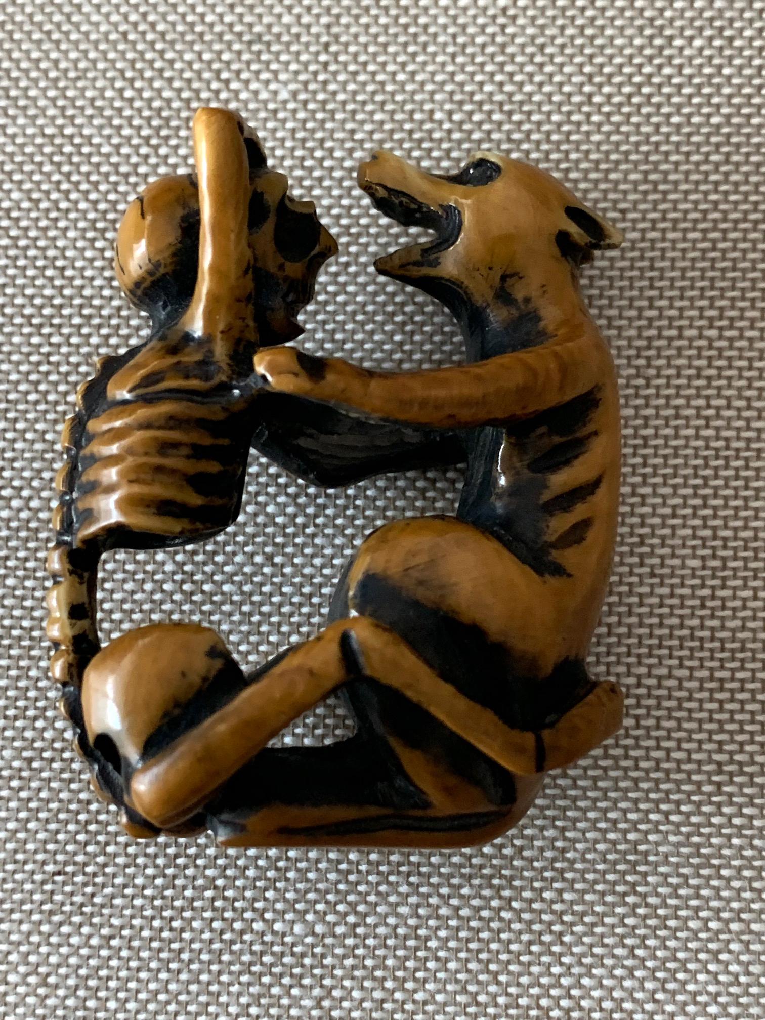 An antique wood netsuke circa 19th century. It depicts a wolf embracing a skeleton. Signed as shown. The pair alludes to the failed love story of Komachi and Fukakasa Shosho. Fukakasa was a tempestuous general who died in vain to prove his love for
