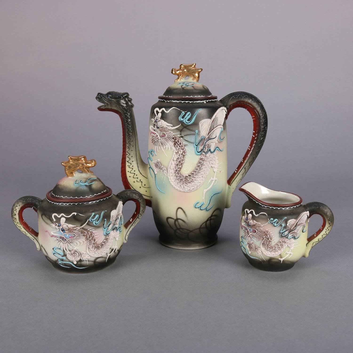 Japanese Nippon Dragon Ware tea set features hand painted moriage dragon decoration and gilt finials, set includes tea pot, creamer and covered sugar, six tea cups and saucers; stamped on bottom; 20th century

Measure: Teapot 8