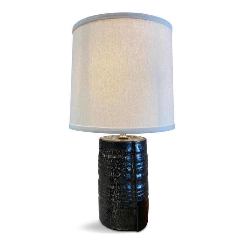 Made in Japan, this sturdy ceramic table lamp has unique, organic ribbing along its base and a glossy jet black and beige tortoiseshell glaze.