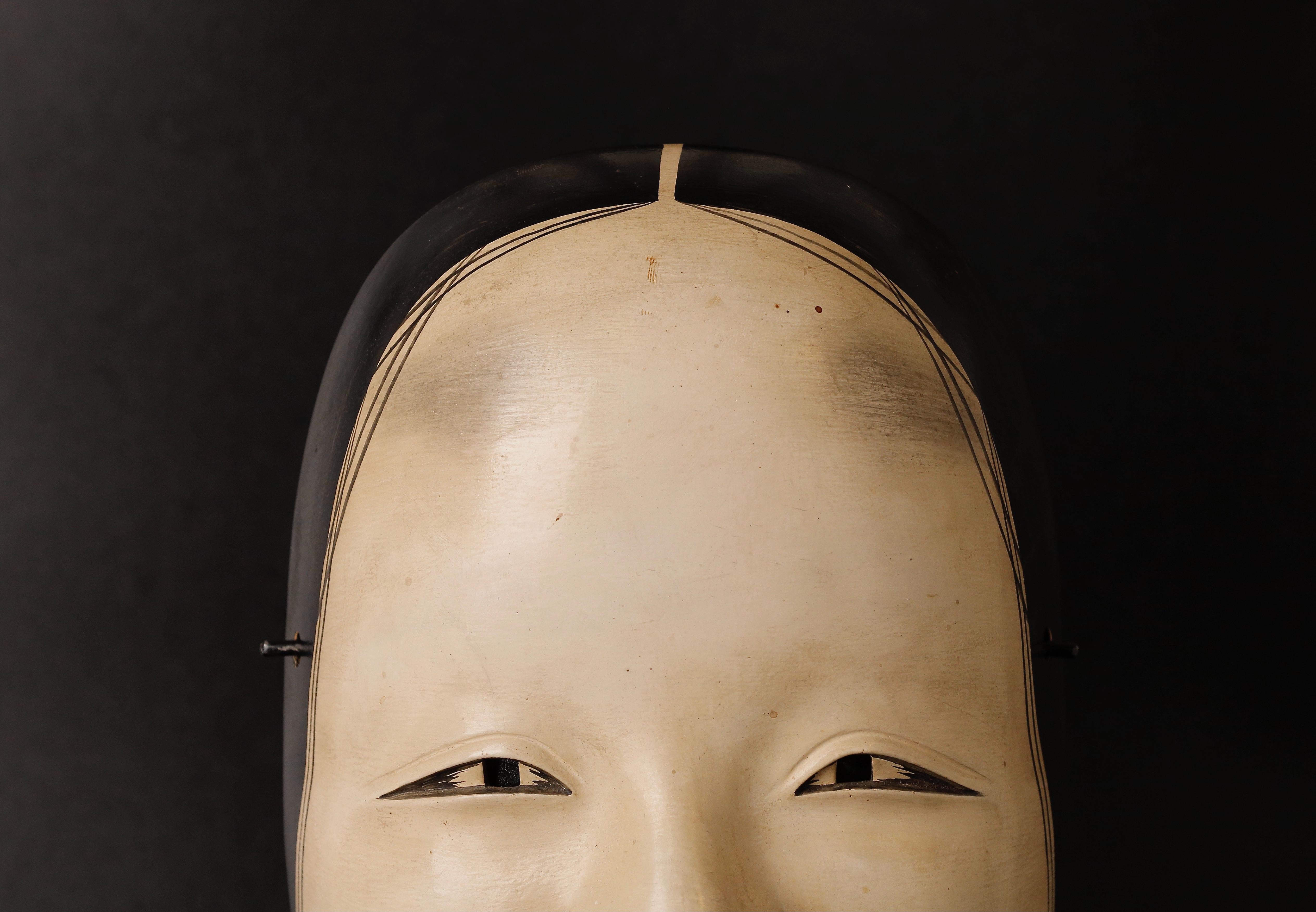 Japanese Noh Mask was crafted at early Edo period. The Japanese Noh Mask depicting Zou-onna that you are considering is an excellent example of a mask that would be used in a Noh play. The mask represents a female deity or woman of high rank, and