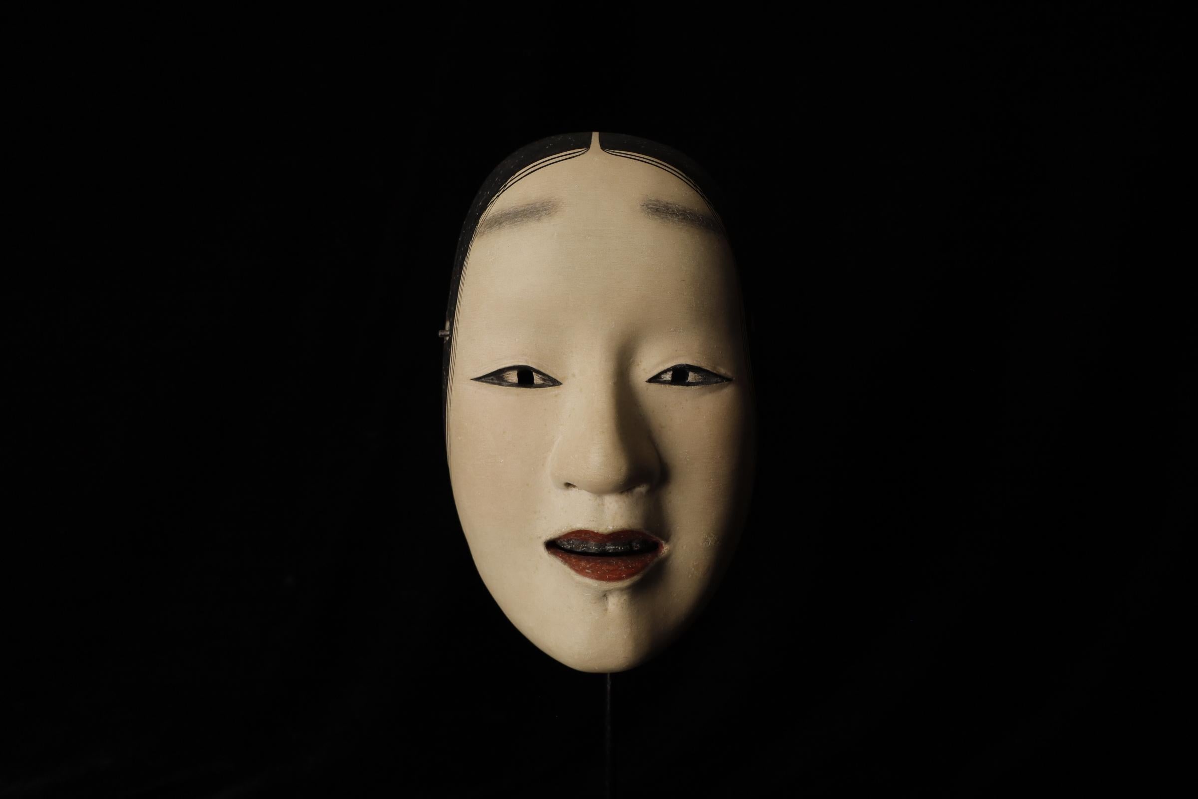 Zō-onna (増女)

This mask depicts a woman with a noble and calm expression. In Noh theater, it is used for roles of young women. The mask conveys elegance and softness, making it suitable for roles related to female characters. There is a theory that