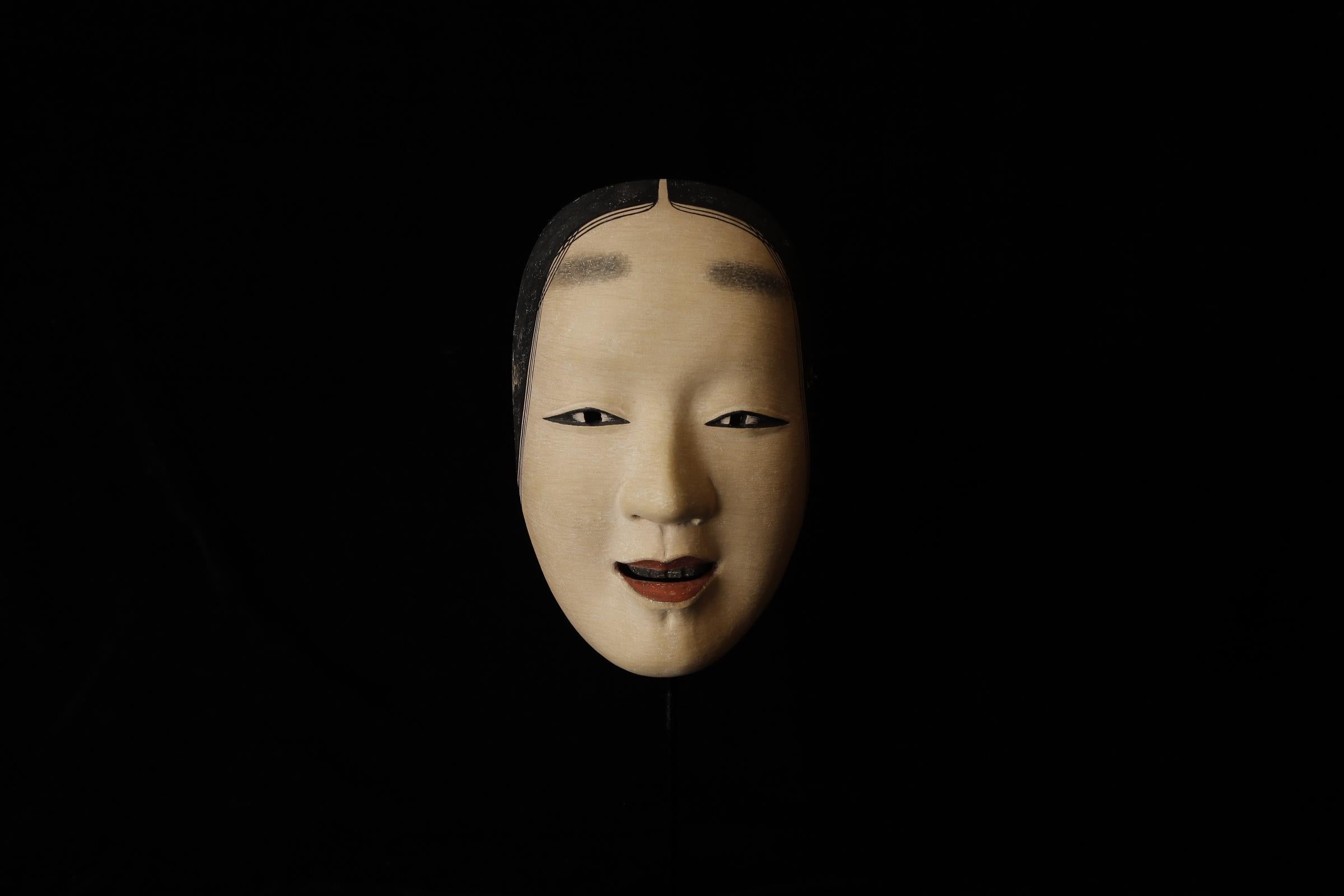 Zō-onna (増女)

This mask depicts a woman with a noble and calm expression. In Noh theater, it is used for roles of young women. The mask conveys elegance and softness, making it suitable for roles related to female characters. There is a theory that