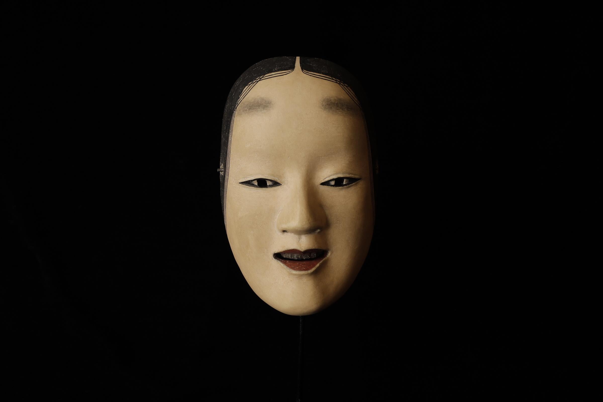 Zō-onna (増女)

This mask depicts a woman with a noble and calm expression. In Noh theater, it is used for roles of young women. The mask conveys elegance and softness, making it suitable for roles related to female characters. There is a theory that