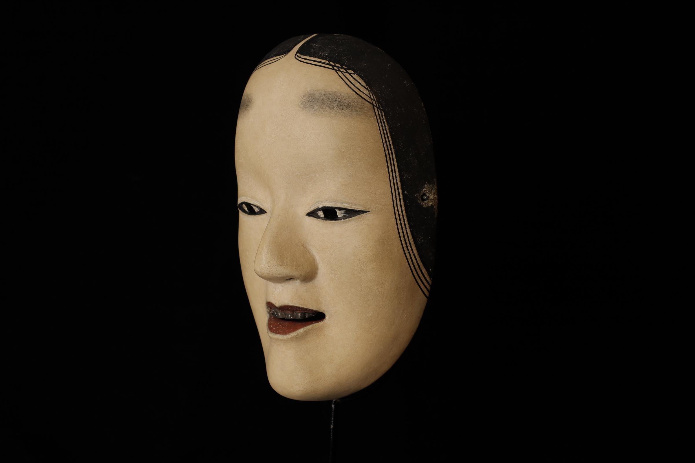 Zō-onna (増女)

This mask depicts a woman with a noble and calm expression. In Noh theater, it is used for roles of young women. The mask conveys elegance and softness, making it suitable for roles related to female characters. There is a theory that