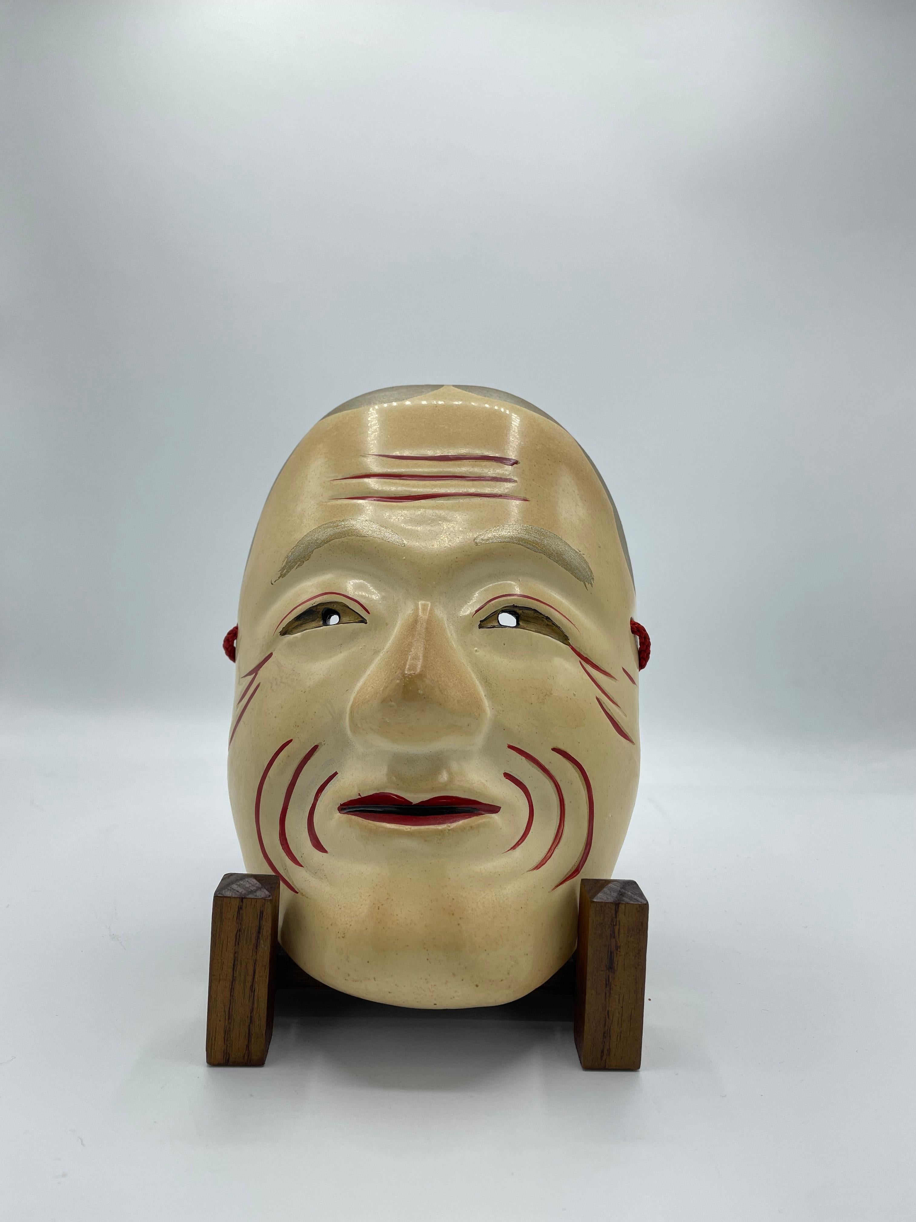 This is a mask made with wood, made in Japan around 1960s.
This mask is used for Noh theatre. On the back, it is written 'TENAZUCHI' in Japanese.
It is all hand painted. 

Dimension: 14 x 7 x H20 cm

Ashinazuchi and Tenazuchi are a pair of Japanese