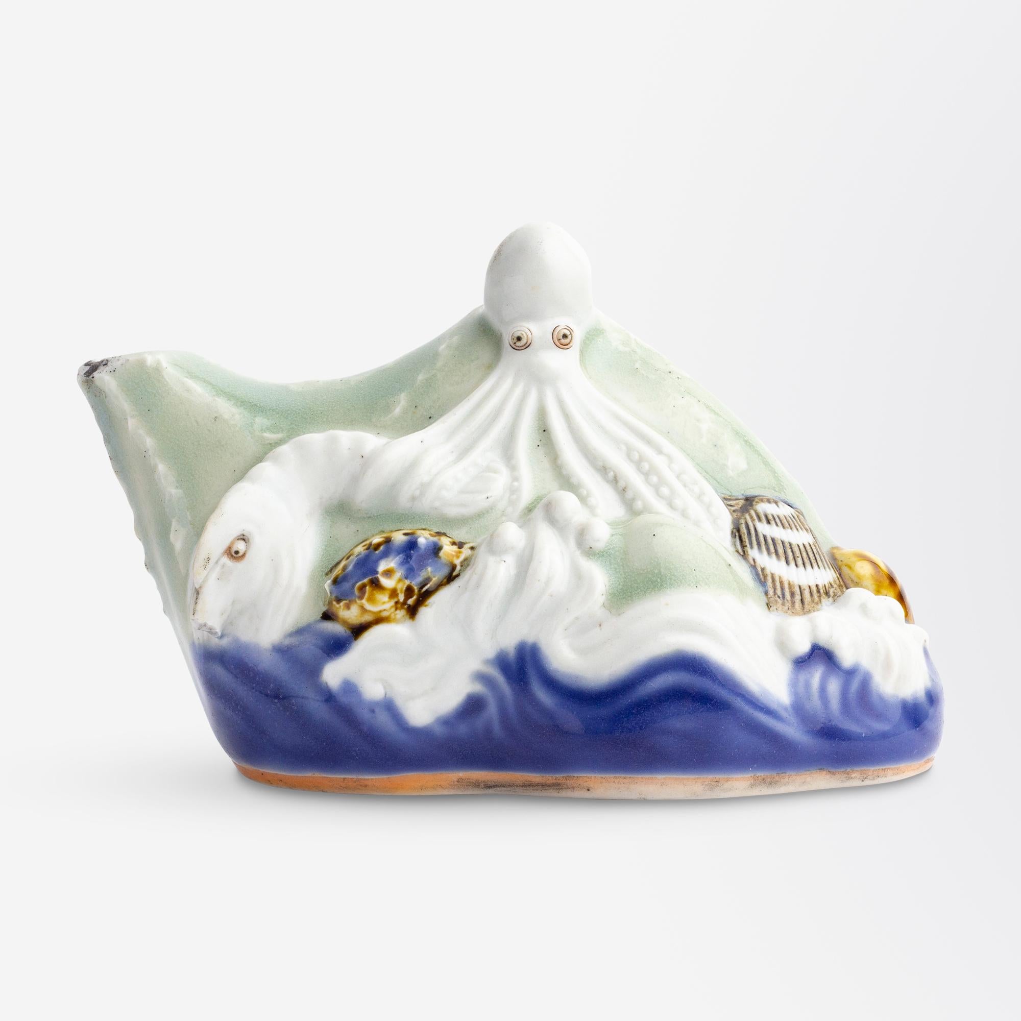 A Japanese Hirado ware water dropper used in calligraphy dating to the Edo Period (1603-1868). The whimsical, molded design features an array of sea creatures and shells on the base of crashing waves. Crafted from Hirado clay, covered in celadon