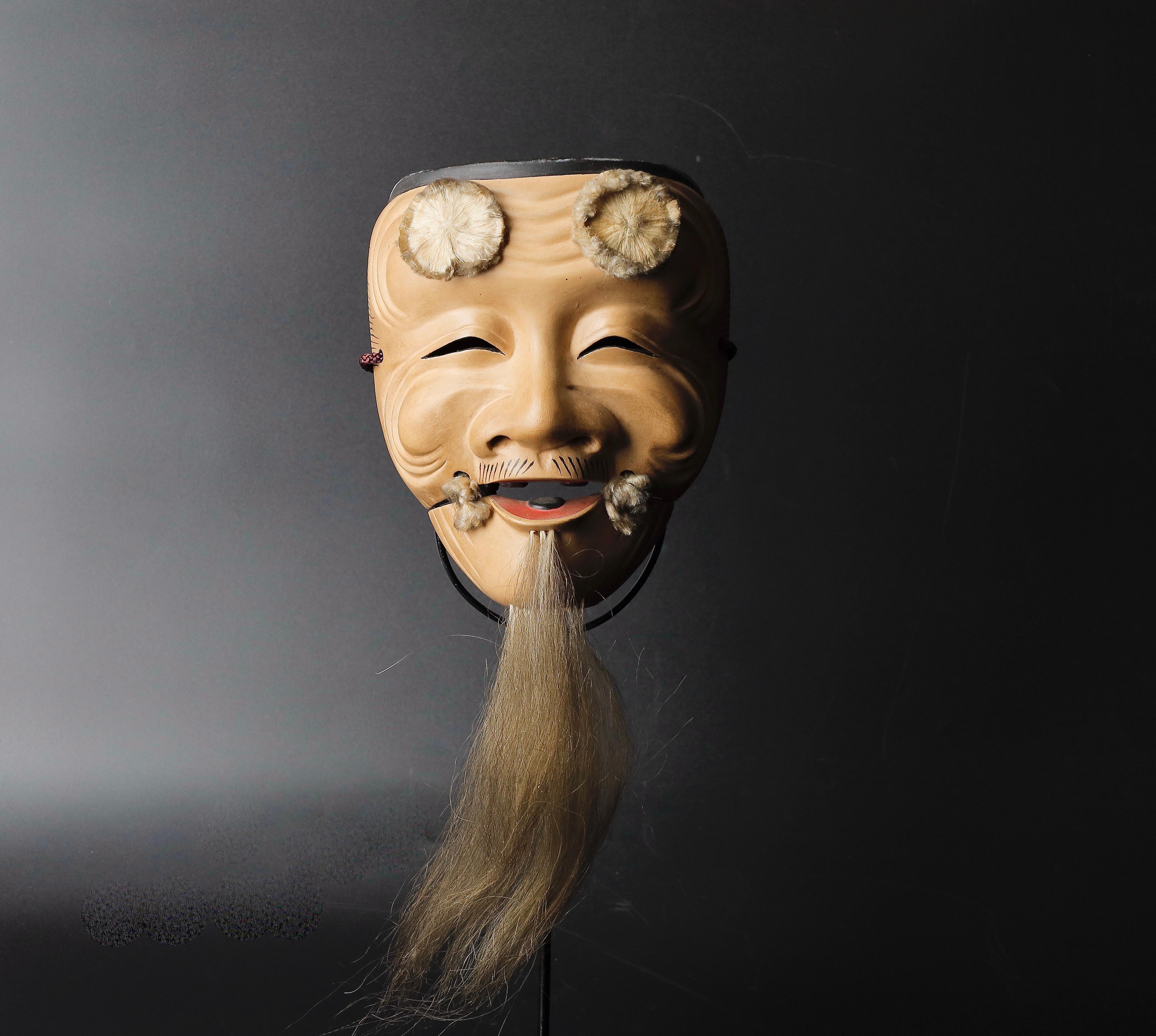 Singed Okina Noh mask old male with long white beard expressing wisdom
Mid 20 th century 
Size: 15 x 19 x8 cm ( 6x 7.5 x 3 inch ) 
Weight: 230g ( 0.5 lb ) 
Material: wood with gofun paint
Small crack under the long beard , please refer photos