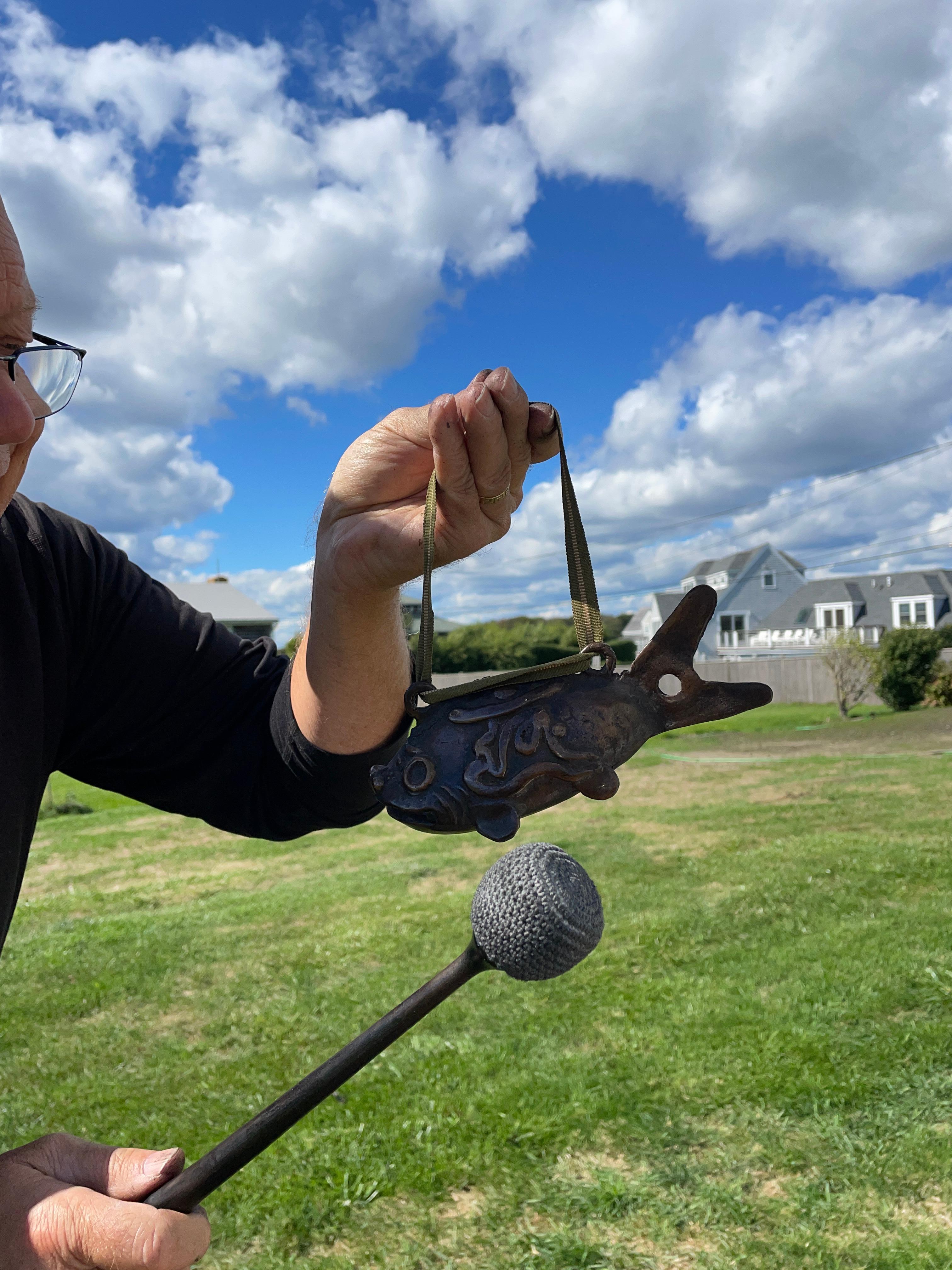 Unusual Japanese original antique bronze temple fish bell and gong in the form of a bream or game fish with an original antique silk suspension cord and hardwood striker. The high quality bronze bell or gong resonates a sound guaranteed to please