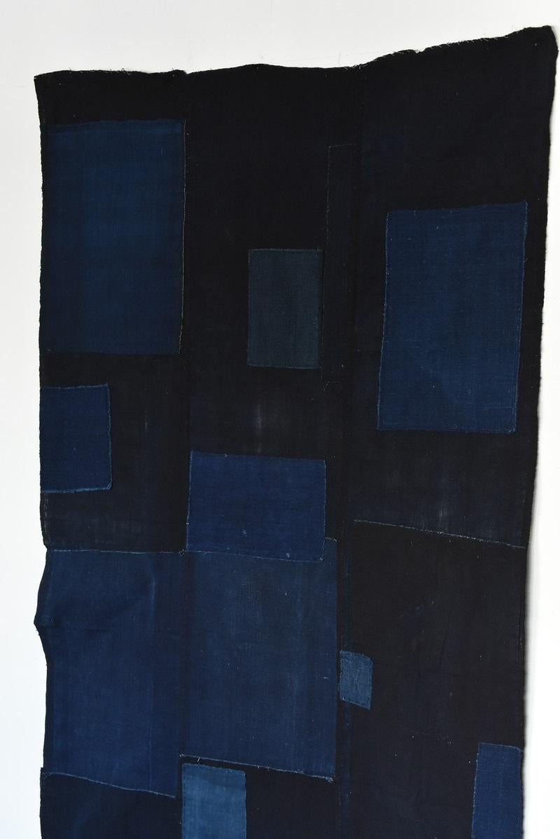 I think this is a remake tapestry using old cloth dyed indigo in the Taisho era in Japan.
It is said that it was made around the Heisei era (1990-2000).
It's abstract and geometric.
It's like a painting by Piet Mondrian in De Stijl.

It's very