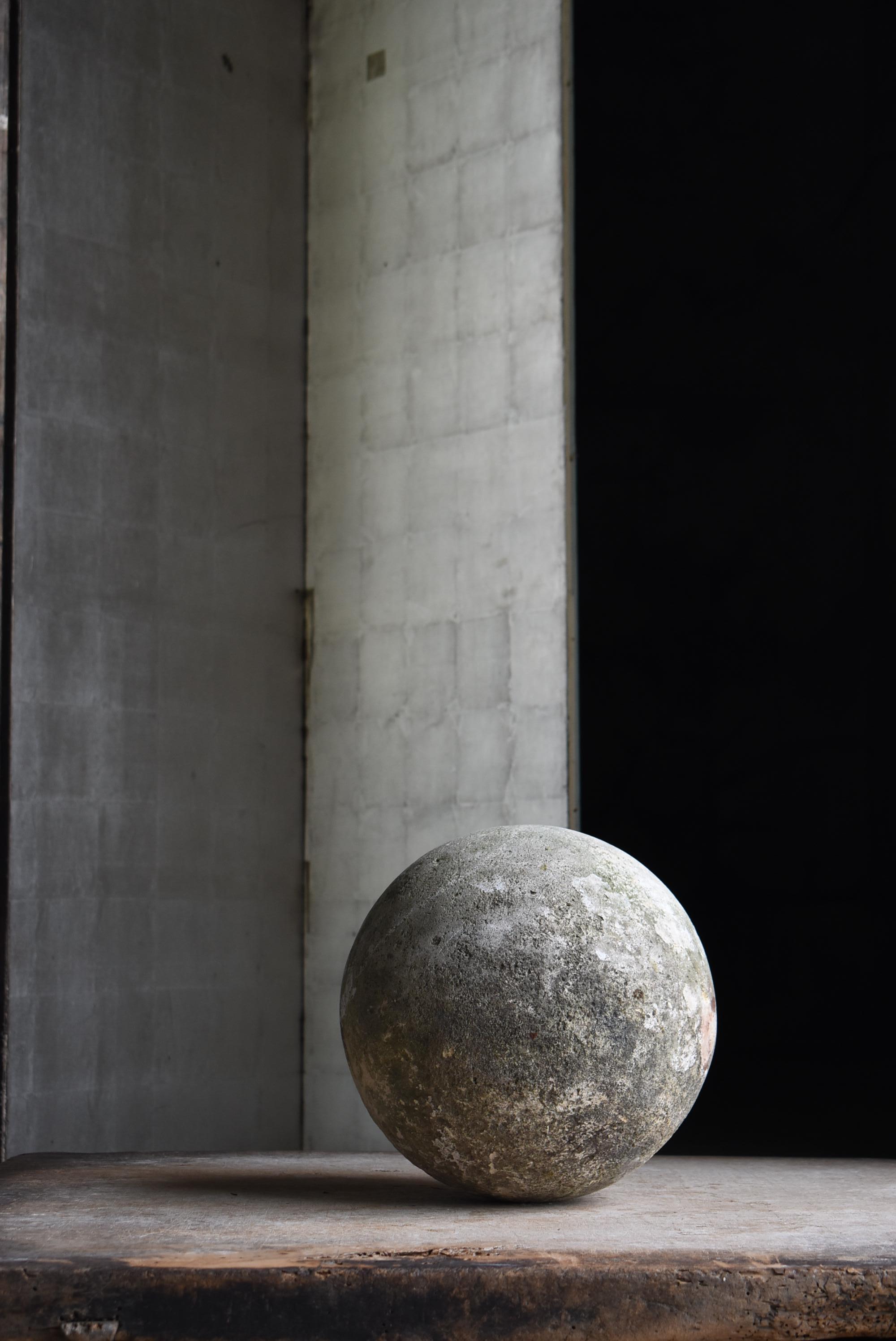 Si tratta di un'antica sfera di cemento giapponese, ammirata per il carattere unico che ha acquisito dopo decenni di esposizione agli elementi. La sua superficie è leggermente ricoperta di muschio, accentuata da tracce di depositi di calce e aree di