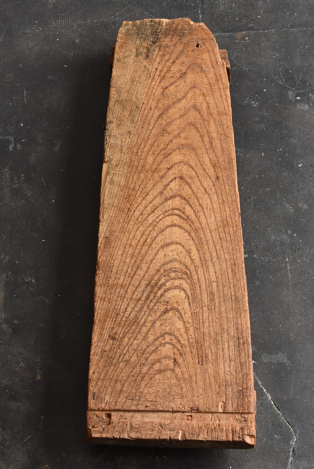 Keyaki (= Zelkova) is one of the finest woods in Japan.
This is hard and heavy wood.
Therefore, it is often used as a work table for craftsmen.
Probably a table for shaving wood with a plane.

It's not too big, so you can use it as a bench seat